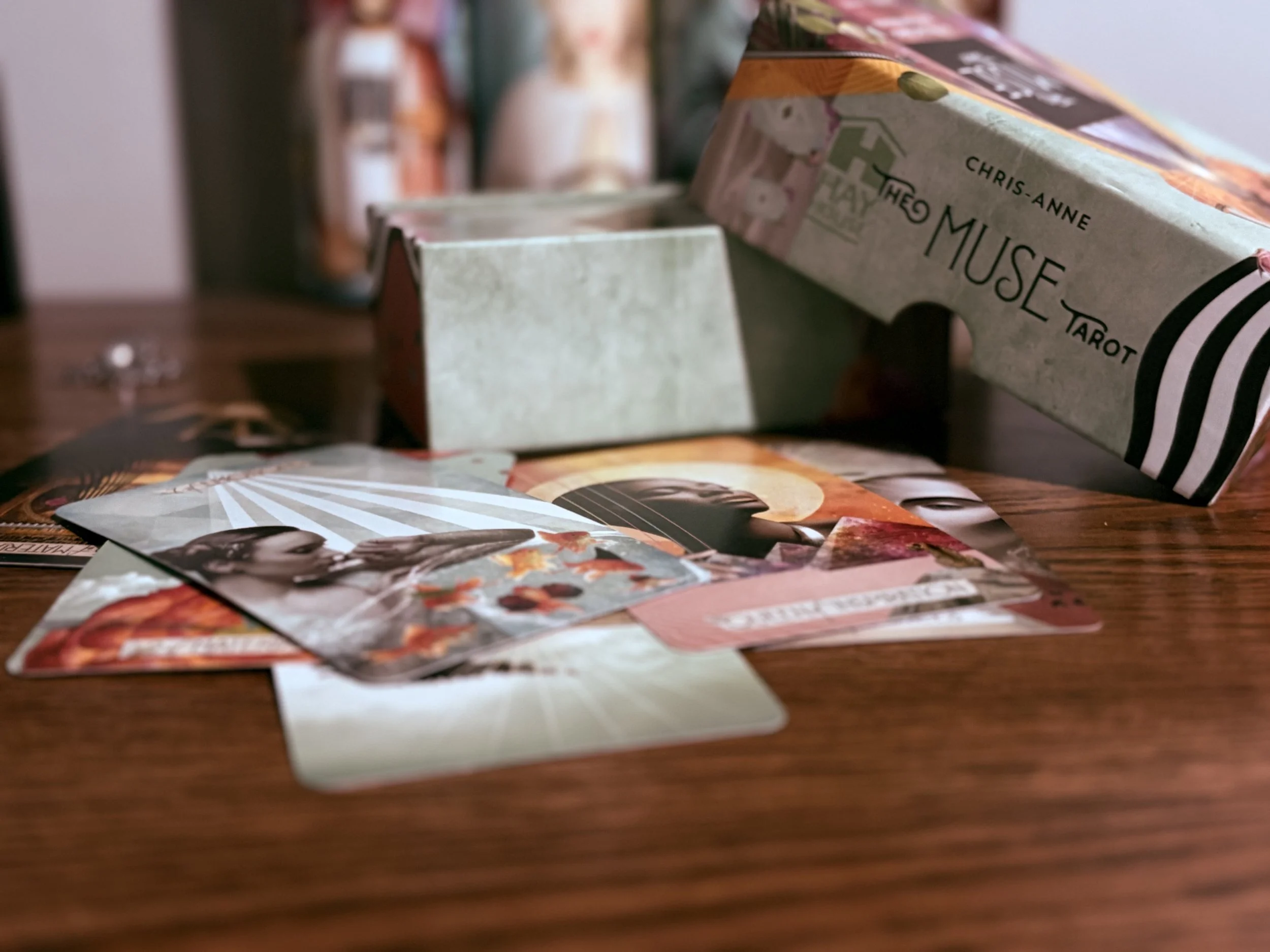Close-up of tarot cards and a deck, with some cards partially visible on a wooden surface.