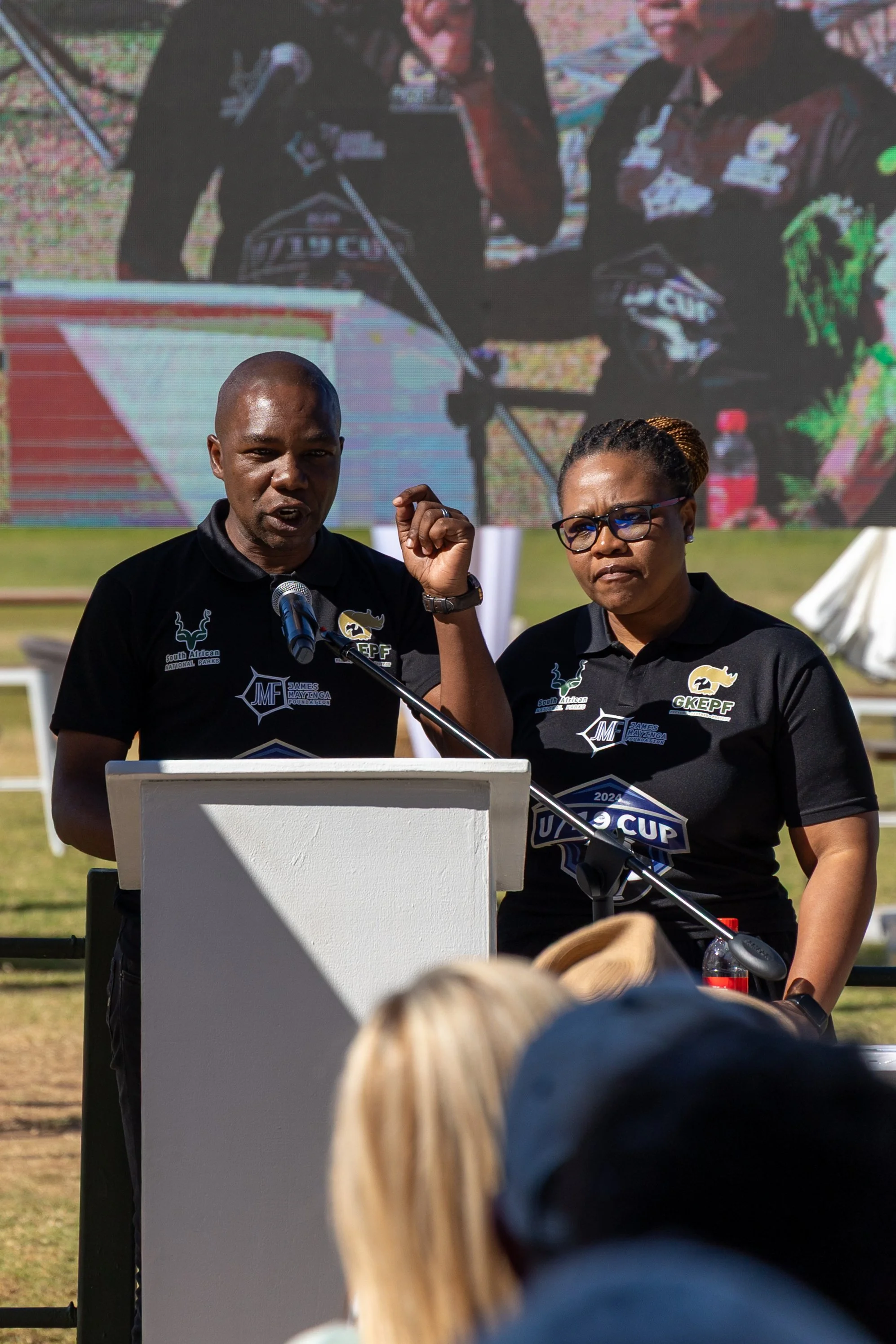 James Mayinga speaking at a podium.