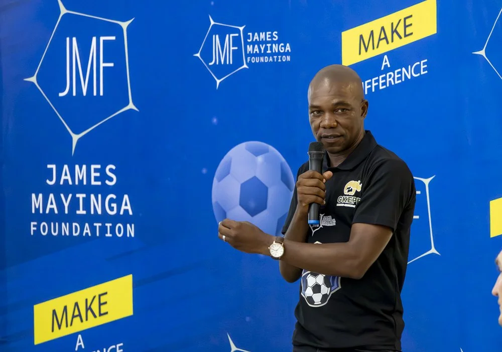 James Mayinga speaking on stage.