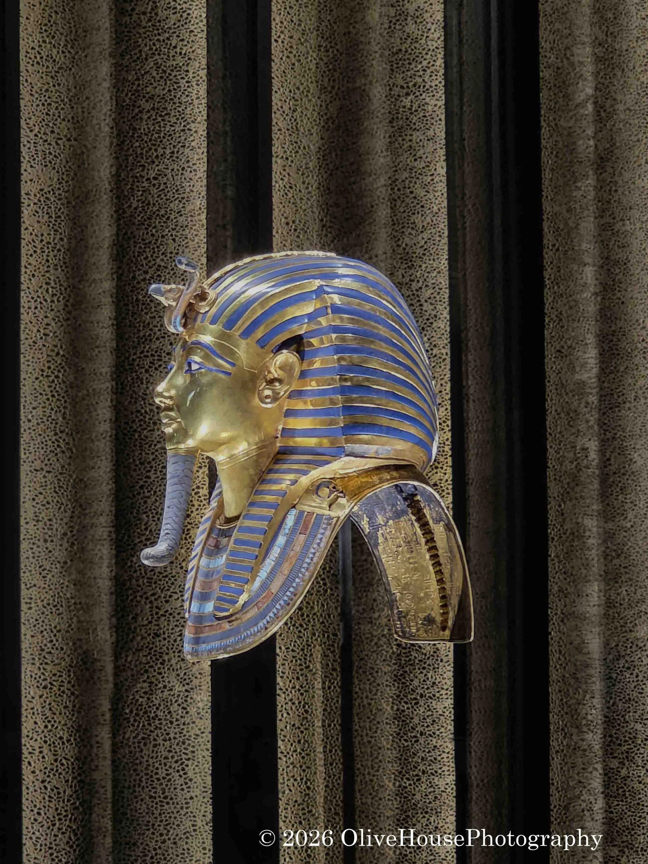 Gold funerary mask of Tutankhamun at the Grand Egyptian Museum. Considered one of the world's most famous treasures, the mask is crafted from 24 pounds of solid gold and inlaid with colored glass and semi-precious stones.