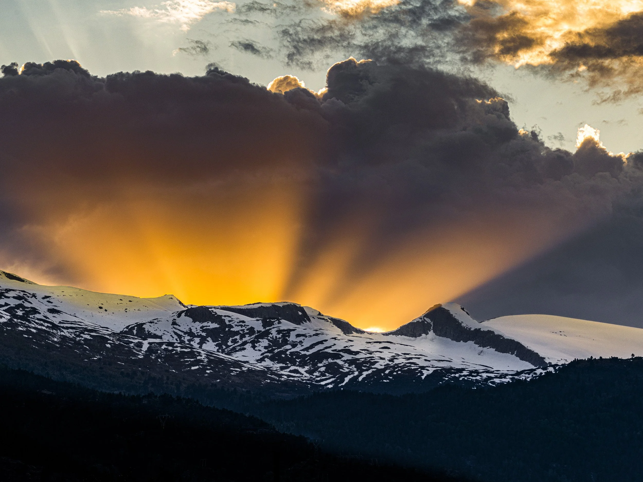Solnedgang sett fra Gaupne, mai 2024.

Idet sola gjekk ned bak fjellet Hest, fekk eg fanga dette unike lyset som fekk ein veldig fin kontrast foran dei mørke skyene bak.