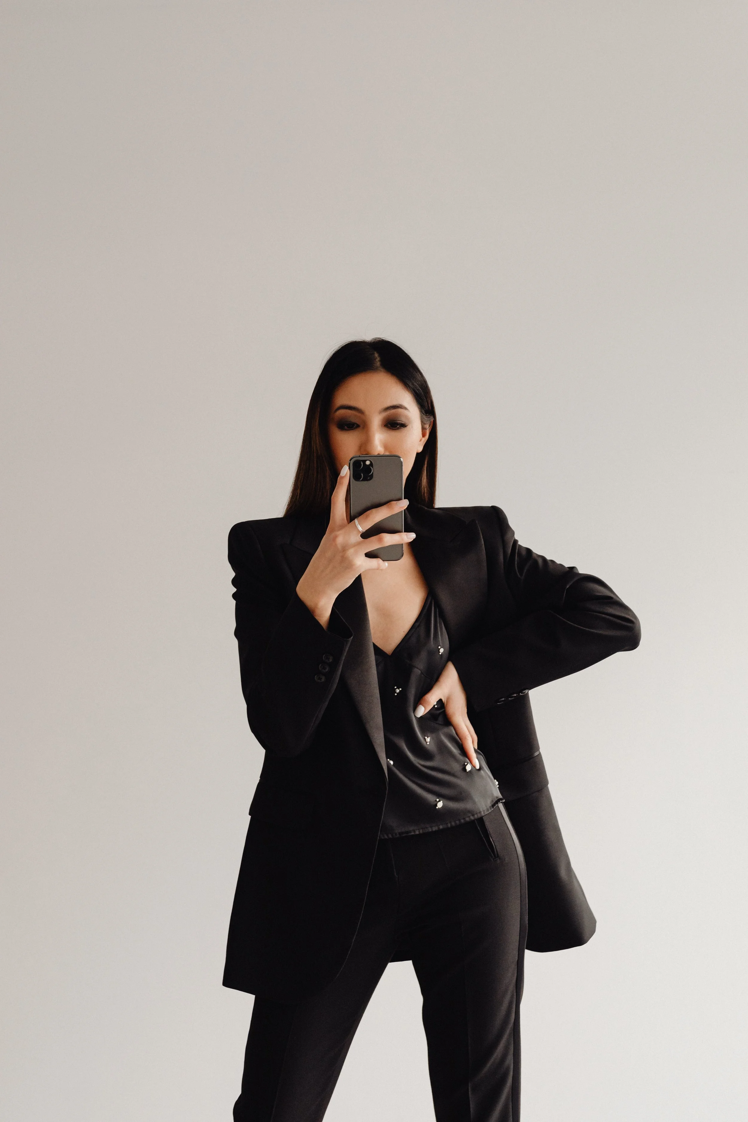 kaboompics_dark-classy-aesthetic-fashion-beautiful-asian-female-entrepreneur-in-black-suit-technology-and-devices-iphone-laptop-airpods-30094.jpg