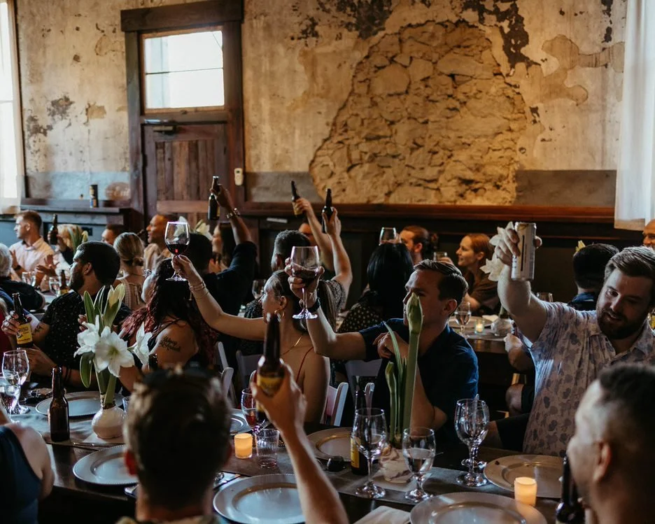 An image of guests raising their glasses at an indoor wedding at StoneHouse101 near Cle Elum. StoneHouse101 is an intimate indoor outdoor events venue in Roslyn, Washington, hosting weddings, birthdays, anniversaries, and more near Cle Elum, WA.