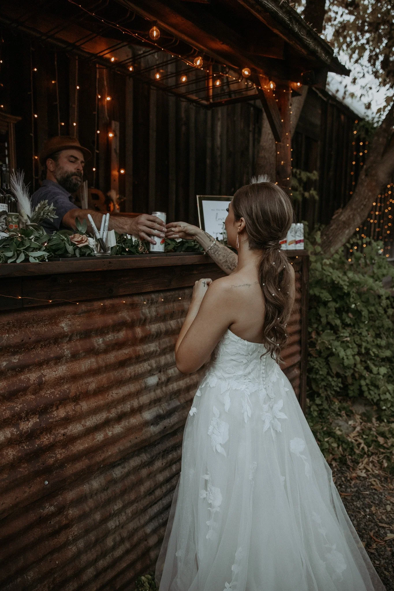 An image of a bride ordering a drink at the outdoor StoneHouse101 bar. StoneHouse101 is an intimate indoor outdoor events venue in Roslyn, Washington, hosting weddings, birthdays, anniversaries, and more near Cle Elum, WA.