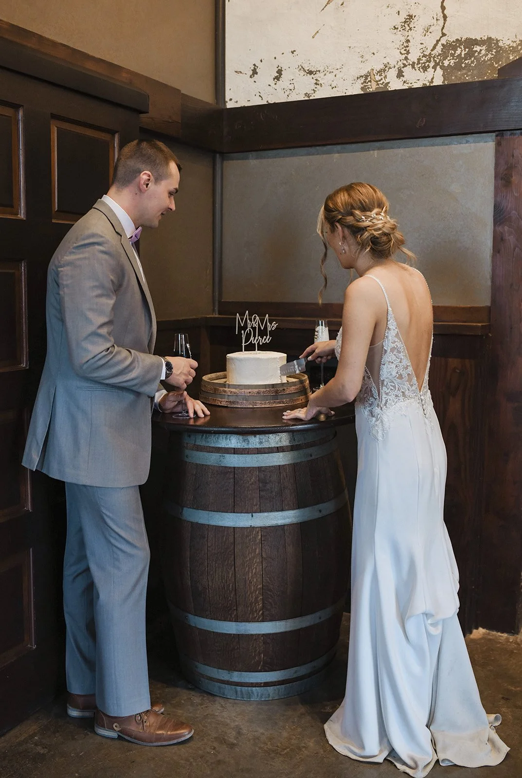 An image of a bride and groom cutting their cake at their indoor wedding venue, StoneHouse101. StoneHouse101 is an intimate indoor outdoor events venue in Roslyn, Washington, hosting weddings, birthdays, anniversaries, and more near Cle Elum, WA.