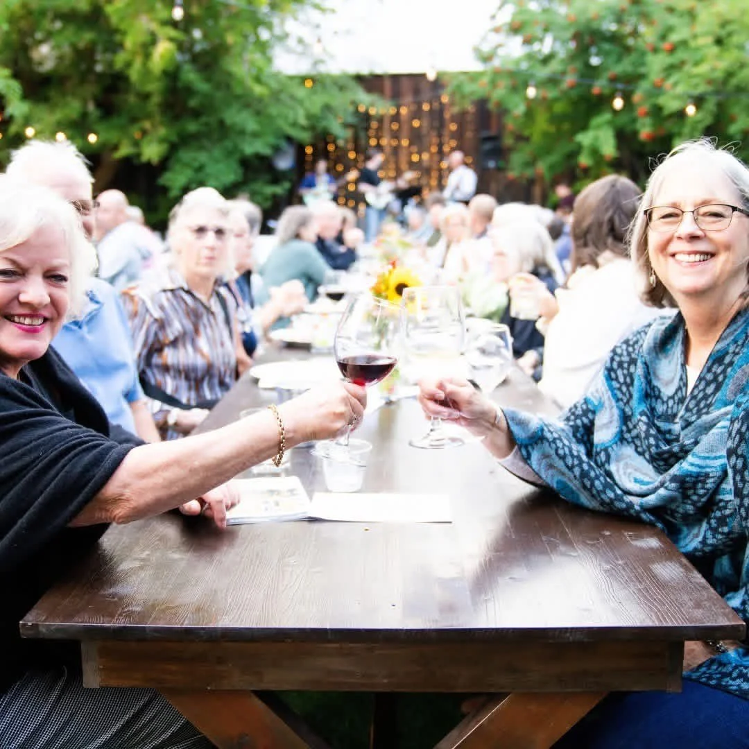 An image of guests saying "cheers" at StoneHouse101. StoneHouse101 is an intimate indoor outdoor events venue in Roslyn, Washington, hosting weddings, birthdays, anniversaries, and more near Cle Elum, WA.