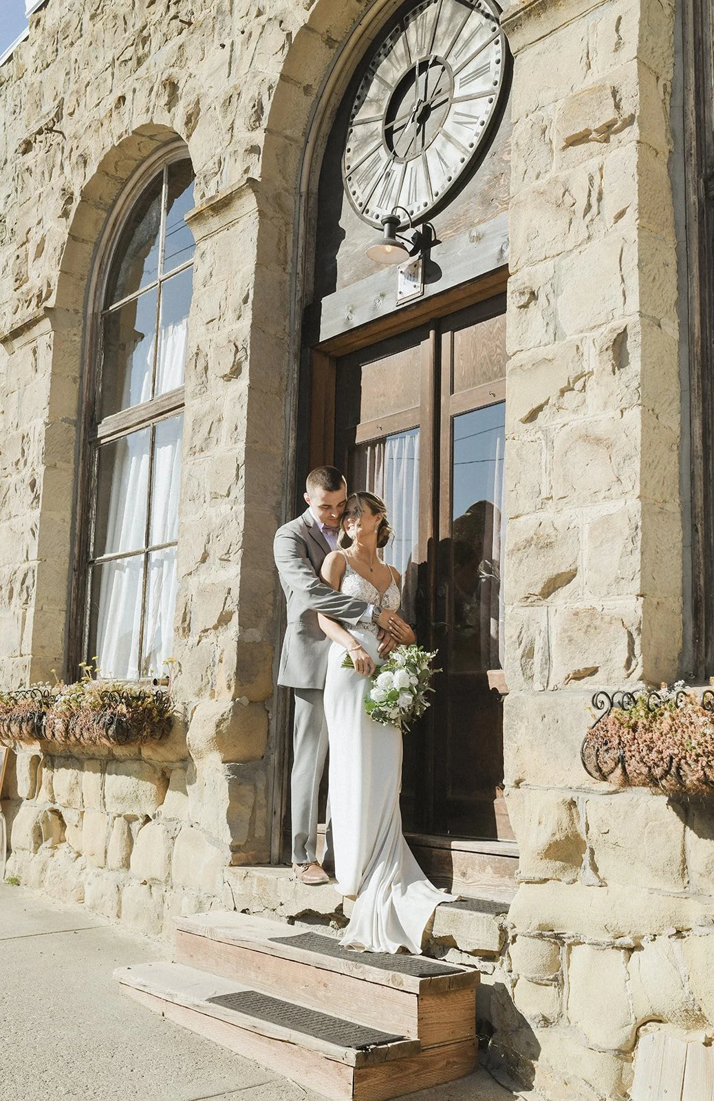 An image of a bride and groom posing outside of StoneHouse101. StoneHouse101 is an intimate indoor outdoor events venue in Roslyn, Washington, hosting weddings, birthdays, anniversaries, and more near Cle Elum, WA.