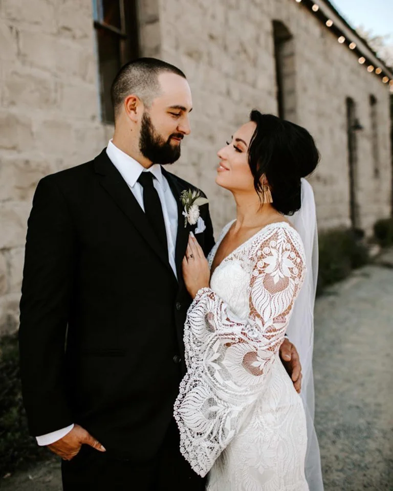 An imag of a bride and groom smiling outside of StoneHouse101. StoneHouse101 is an intimate indoor outdoor events venue in Roslyn, Washington, hosting weddings, birthdays, anniversaries, and more near Cle Elum, WA.