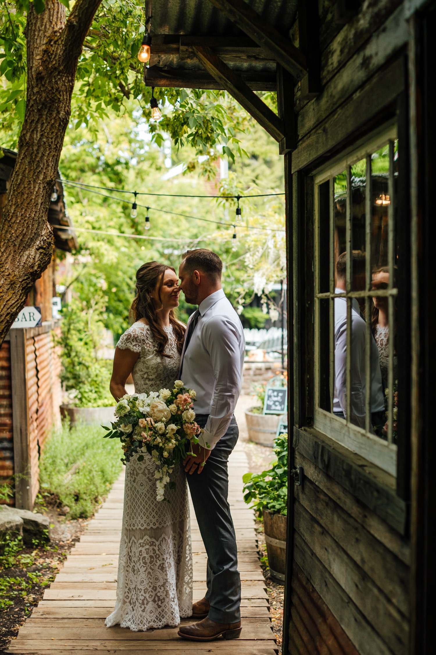 A photo of a bride and groom posing outside of StoneHouse101 Events Venue. StoneHouse101 is an intimate indoor outdoor events venue in Roslyn, Washington, hosting weddings, birthdays, anniversaries, and more near Cle Elum, WA.