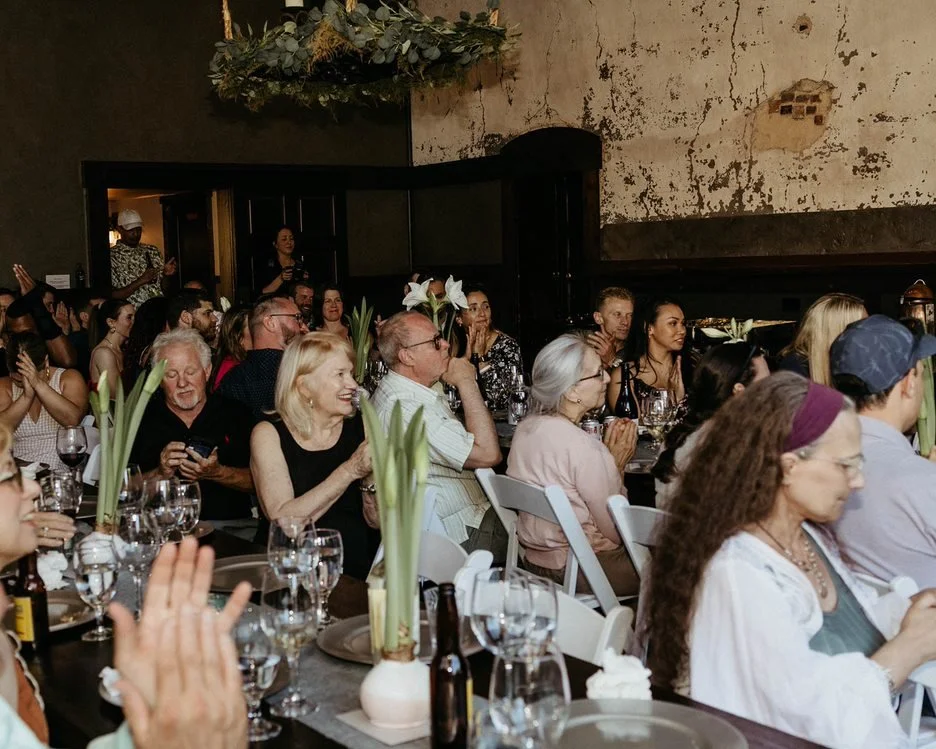An image of guests smiling and clapping at an indoor event at StoneHouse101 Events Venue.