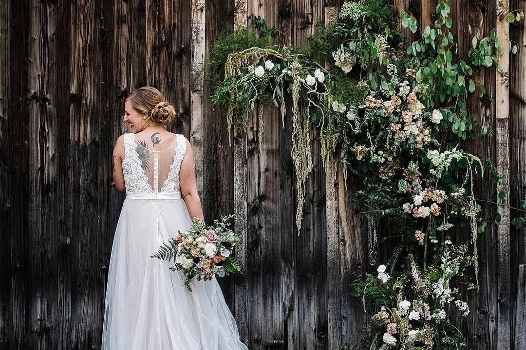 An image of a bride smiling for photos at StoneHouse101. StoneHouse101 is an intimate indoor outdoor events venue in Roslyn, Washington, hosting weddings, birthdays, anniversaries, and more near Cle Elum, WA.