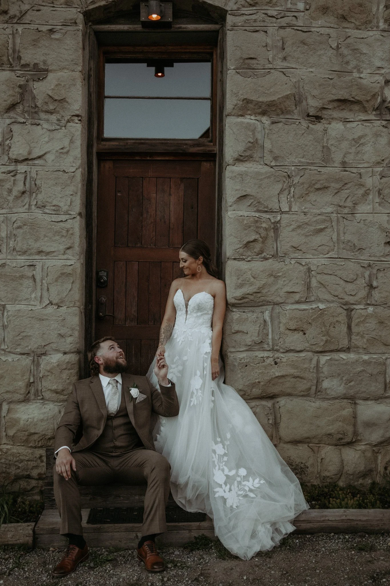 An image of a bride and groom posing outside of StoneHouse101's entrance. StoneHouse101 is an intimate indoor outdoor events venue in Roslyn, Washington, hosting weddings, birthdays, anniversaries, and more near Cle Elum, WA.