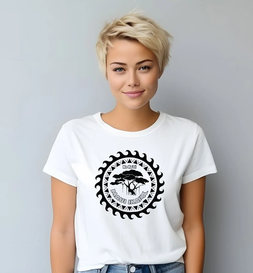 A young woman with short, platinum blonde hair smiling at the camera, wearing a white T-shirt with a black circular logo featuring a tree and the text "No Ka oi Maui Ukulele."