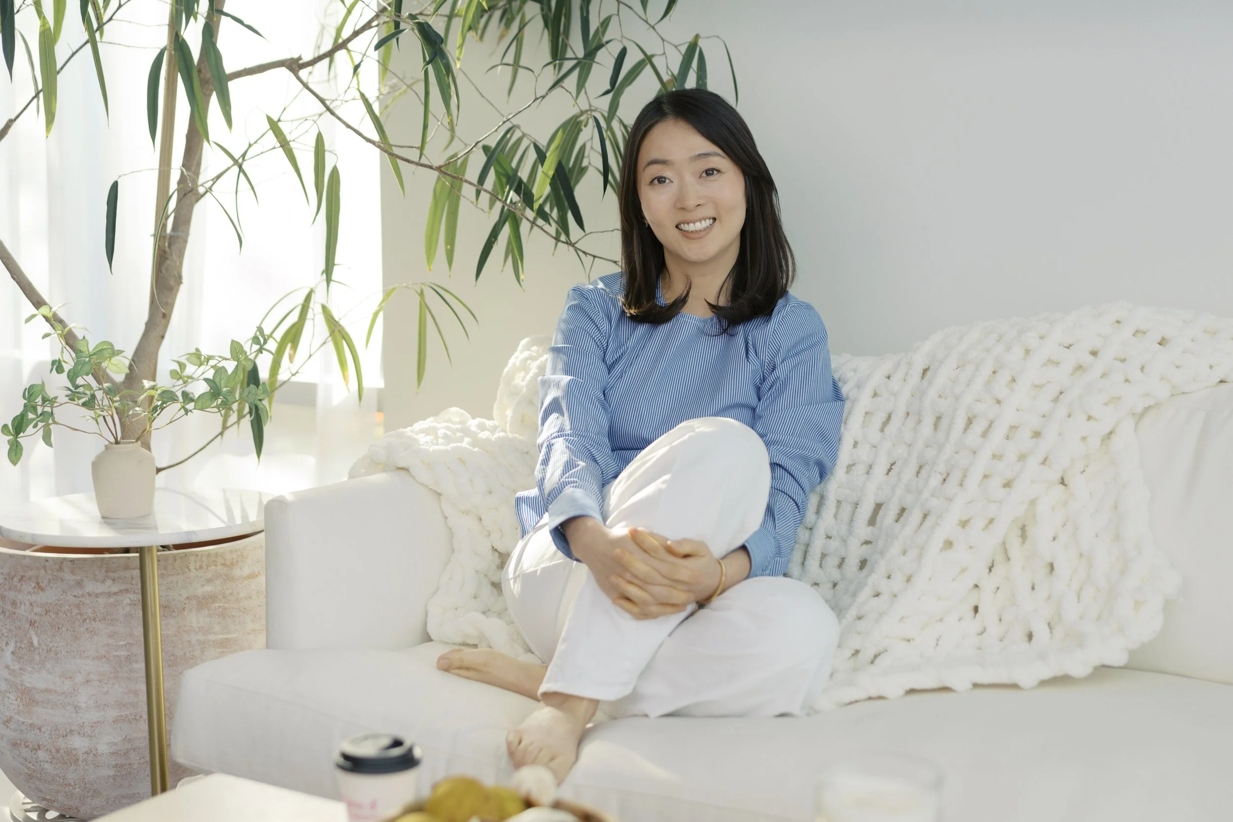 Therapist Juhee smiling in her Austin Texas therapy space, where she leads inner child and inner mothering sessions.