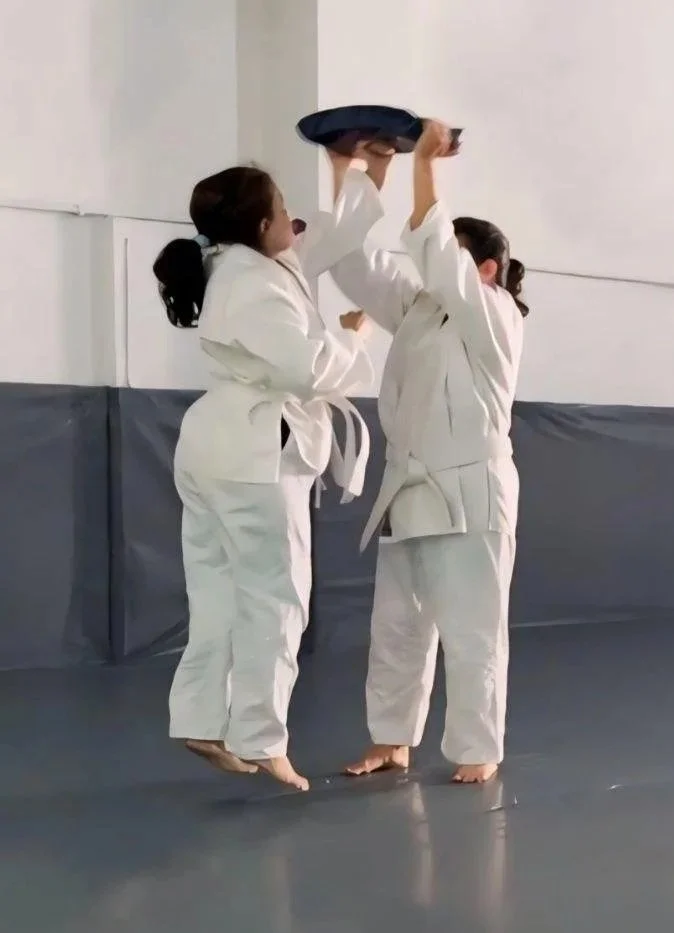 Two Bukan Krav-Maga students practicing punches using a magenim.