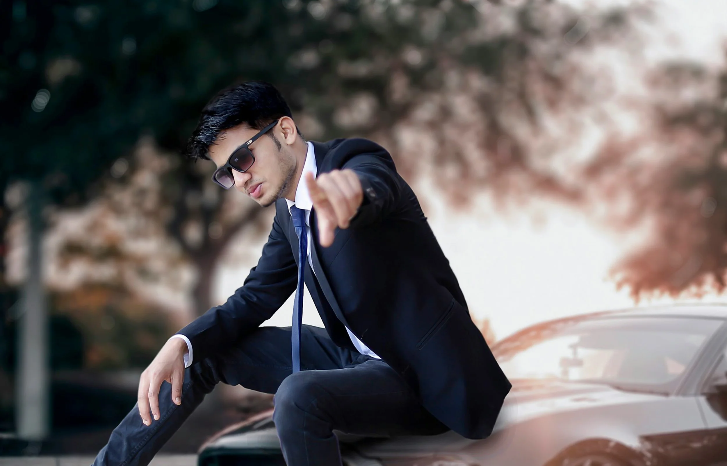 Young man sitting on a car