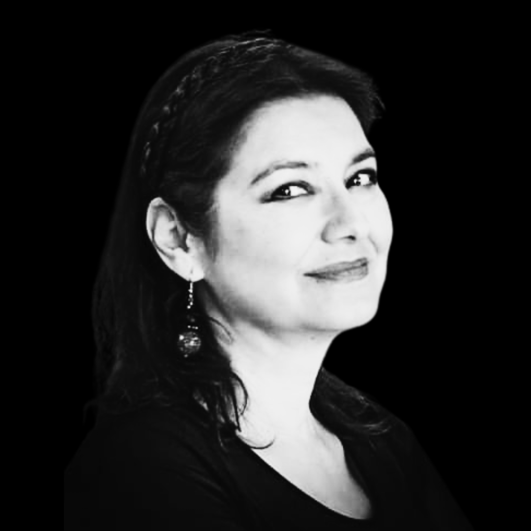 Black and white portrait of a woman with dark hair, wearing earrings, a patterned scarf, and a dark top, smiling softly.