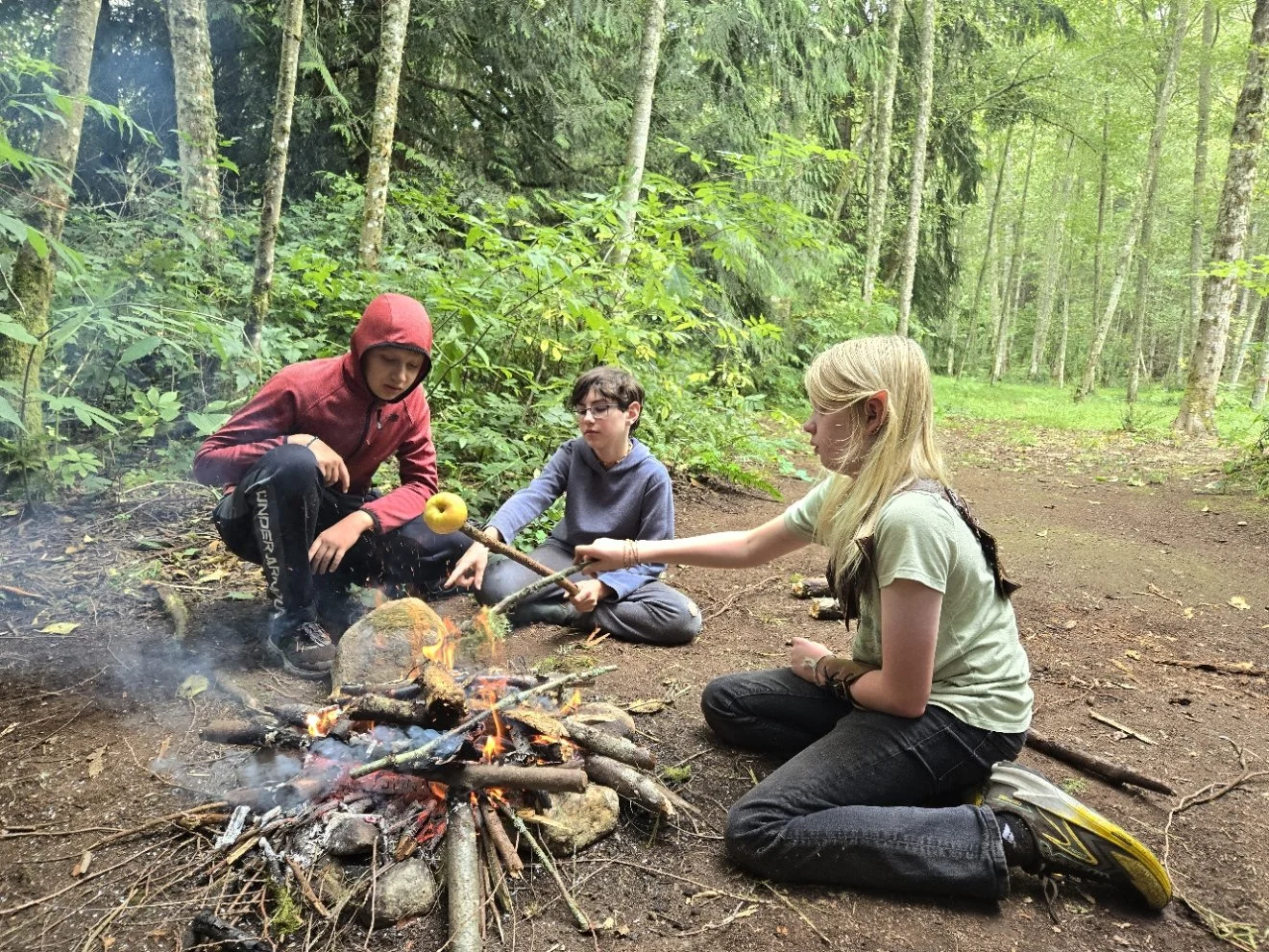 Kids eating around a fire