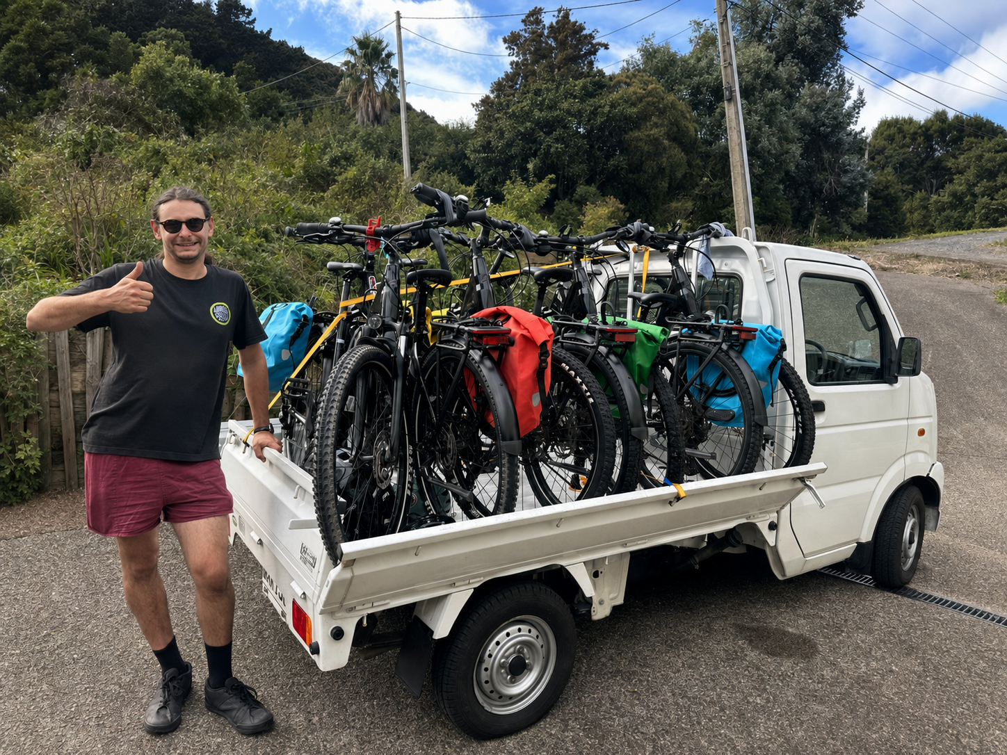 Evan from Waiheke Cycles beside a delivery truck loaded with rental e-bikes