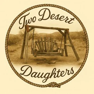 A sepia-toned logo with a circular rope border featuring a wooden swing set and the words 'Two Desert Daughters' in stylized font.