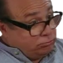 Close-up of a person with glasses and short brown hair, looking sideways with a neutral expression.