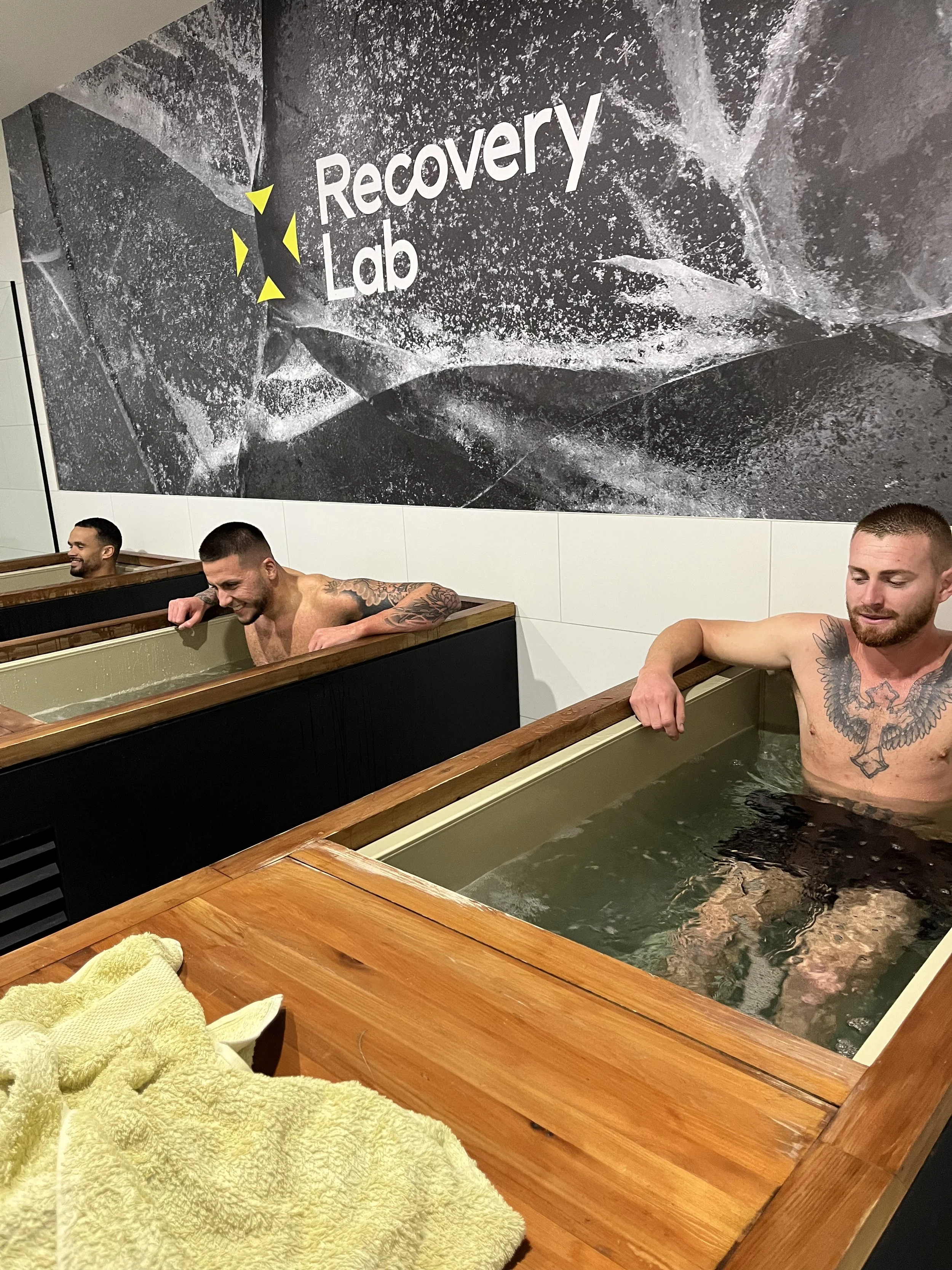 Cold water immersion and recovery tubs at Recovery Lab Maribyrnong during a group recovery session.