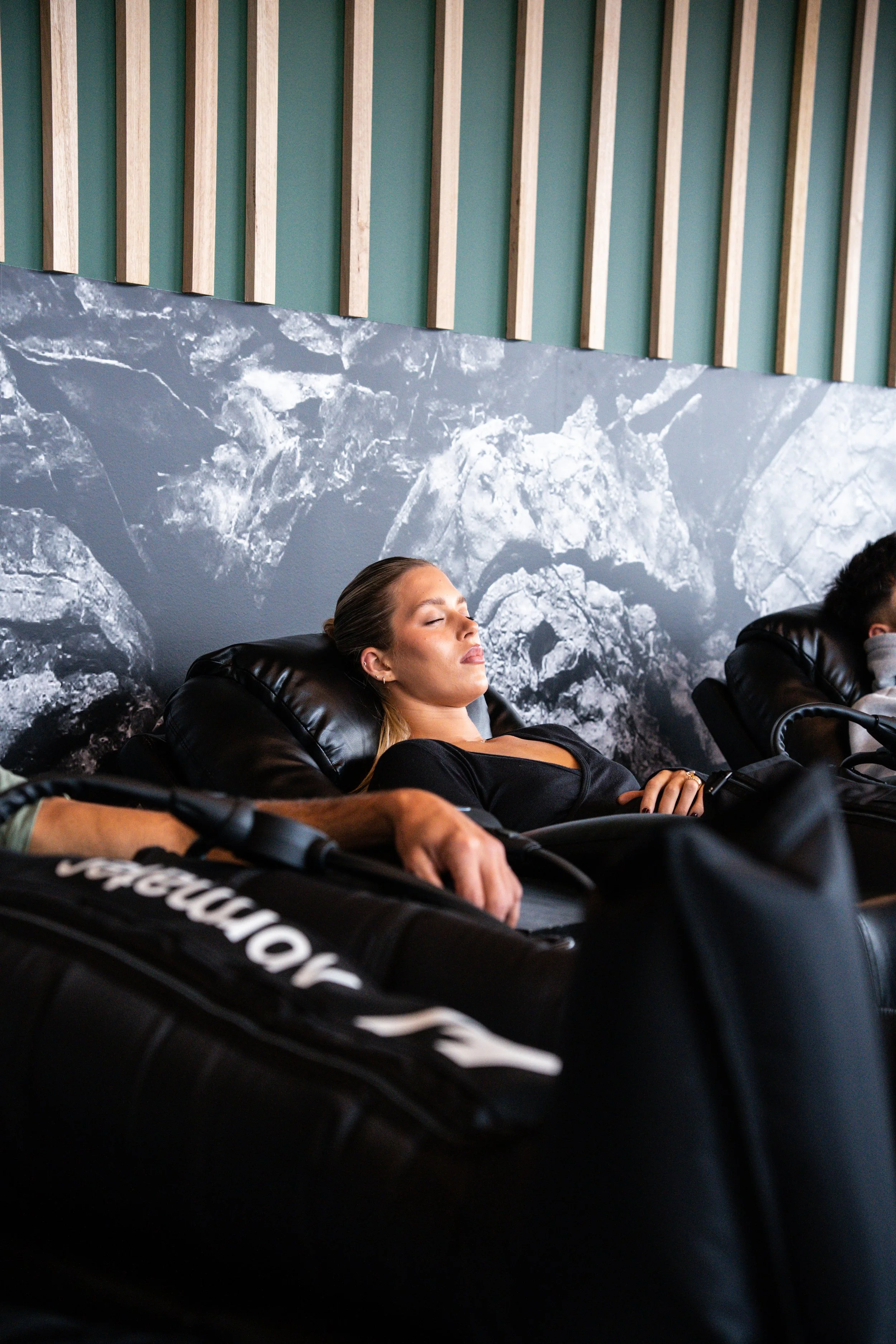 Client relaxing during a compression therapy session in the Recovery Lab Maribyrnong recovery lounge.