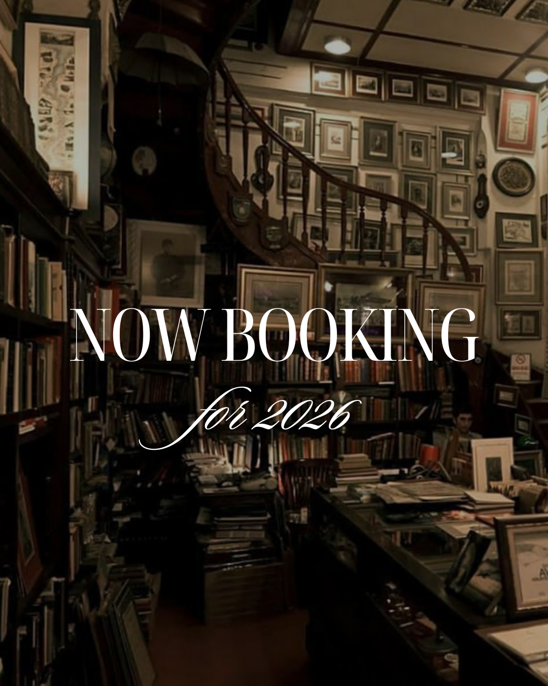 A cozy bookstore or library with walls covered in framed pictures and shelves filled with books. Text overlay reads 'NOW BOOKING for 2026'.