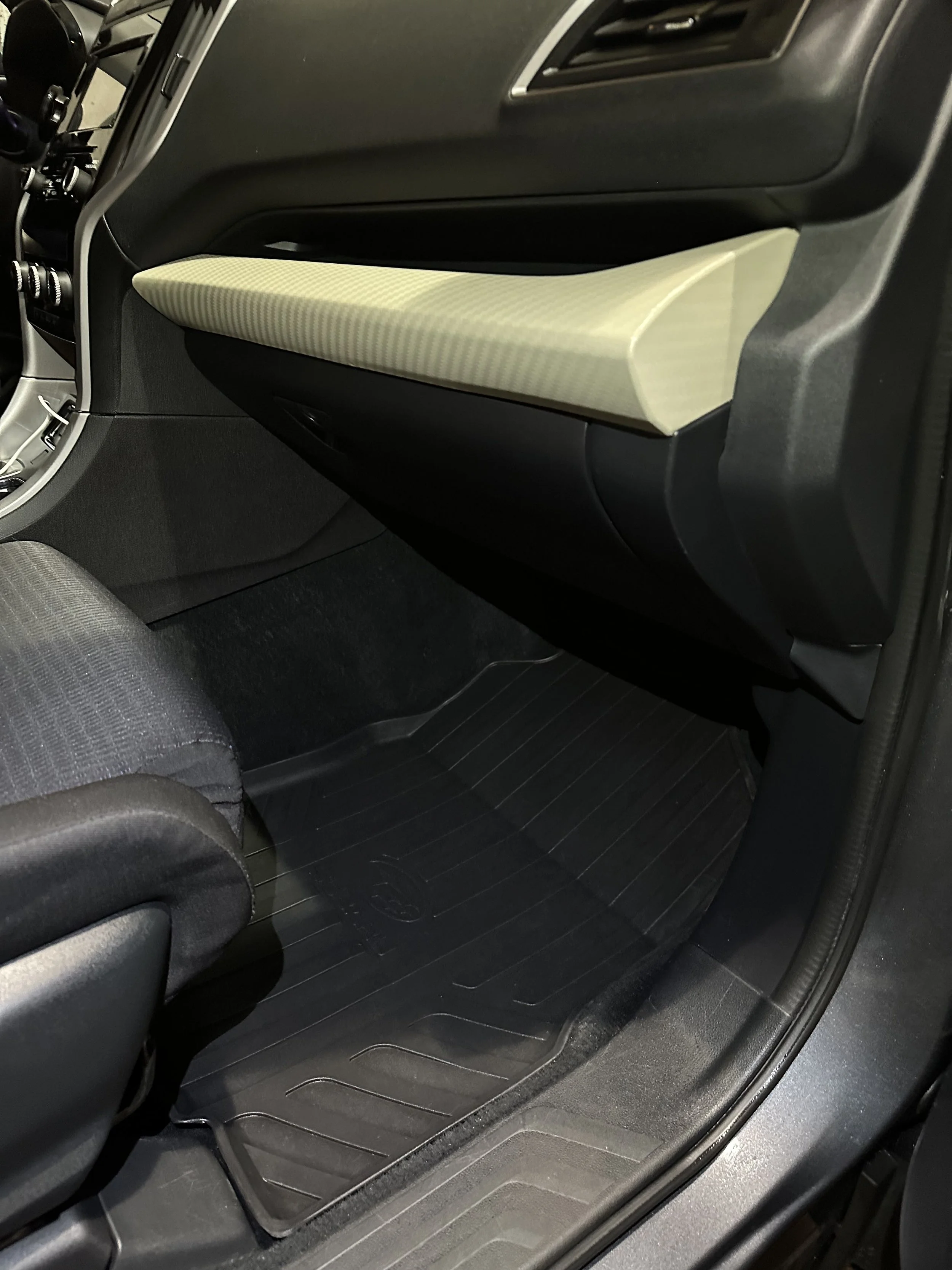 Inside view of a car's cleaned front passenger area showing black floor mat, gray fabric seat, and dashboard with a beige glove compartment.