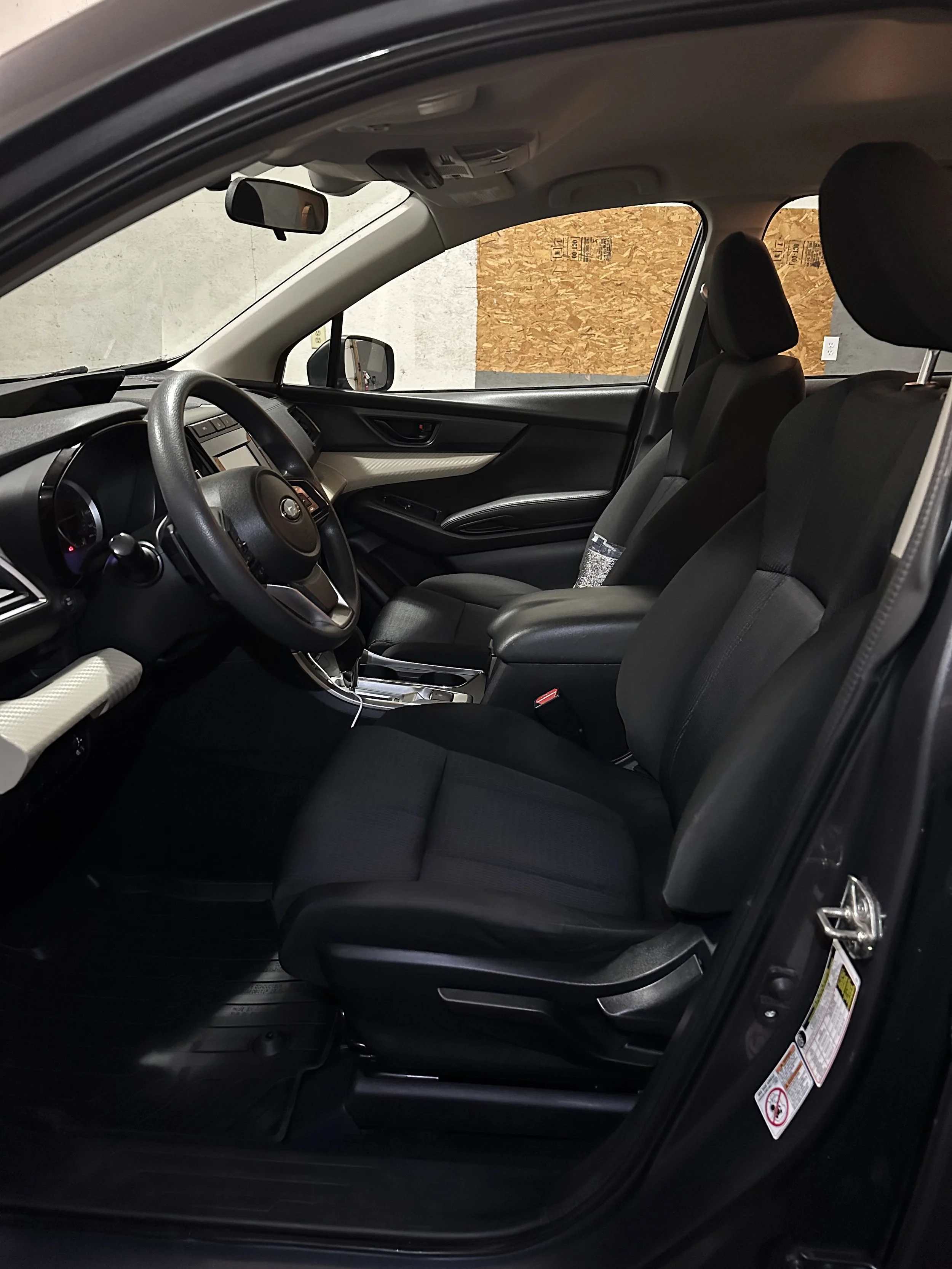 Detailed and clean Interior of a car showing front seats, steering wheel, dashboard, and side door.