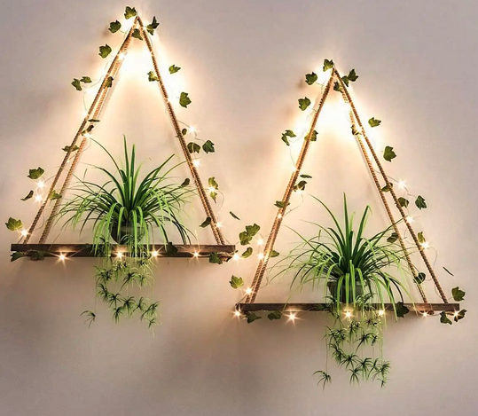 Estantes decorativos en forma de triángulo hechos con cuerdas, con plantas verdes y luces decorativas
