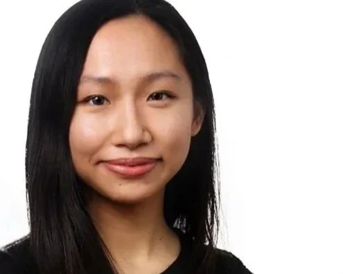 Asian woman with straight black hair wearing black, smiling