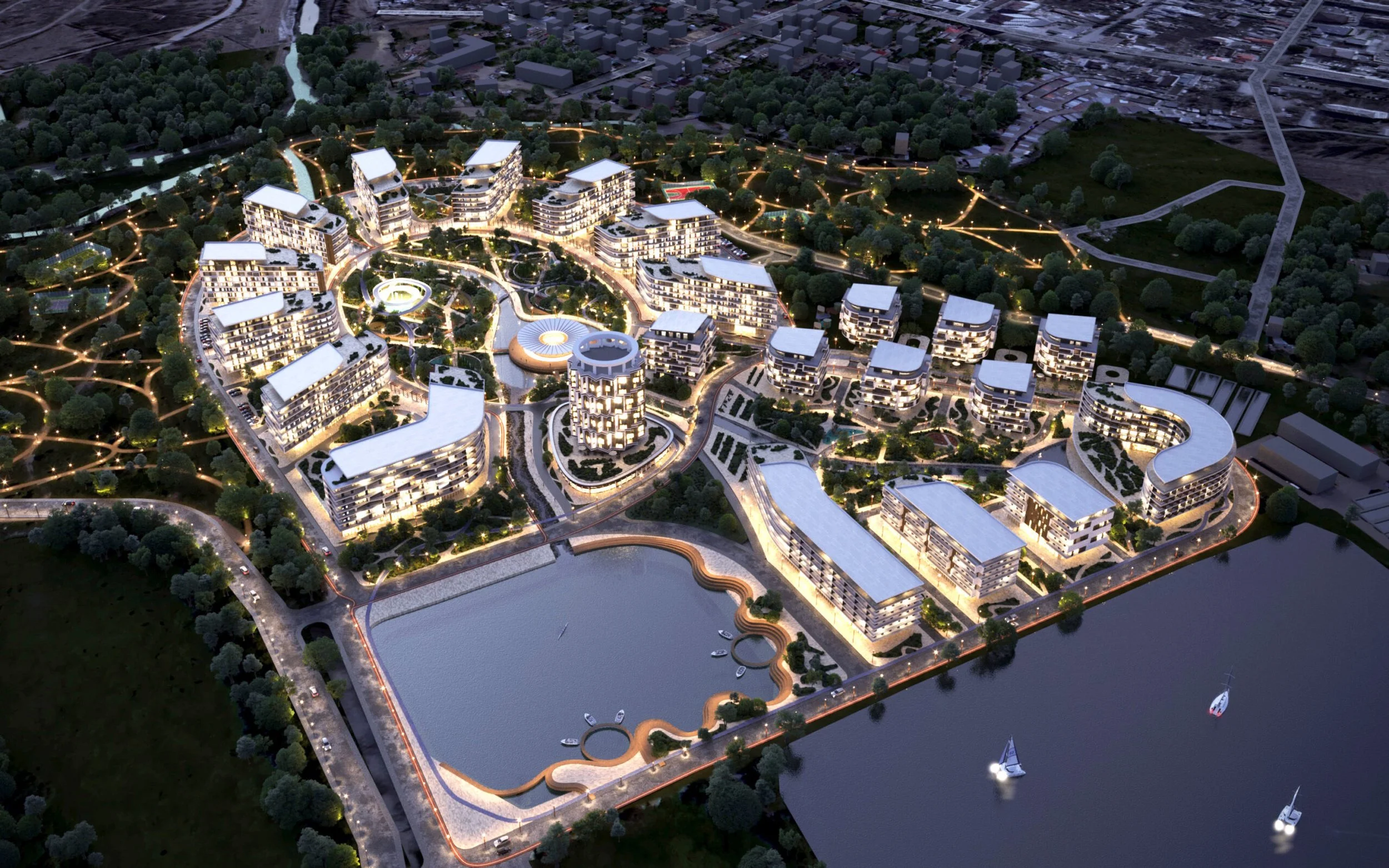 Nighttime aerial view of a modern residential complex with lit buildings, winding pathways, a lake with boats, and surrounding greenery.