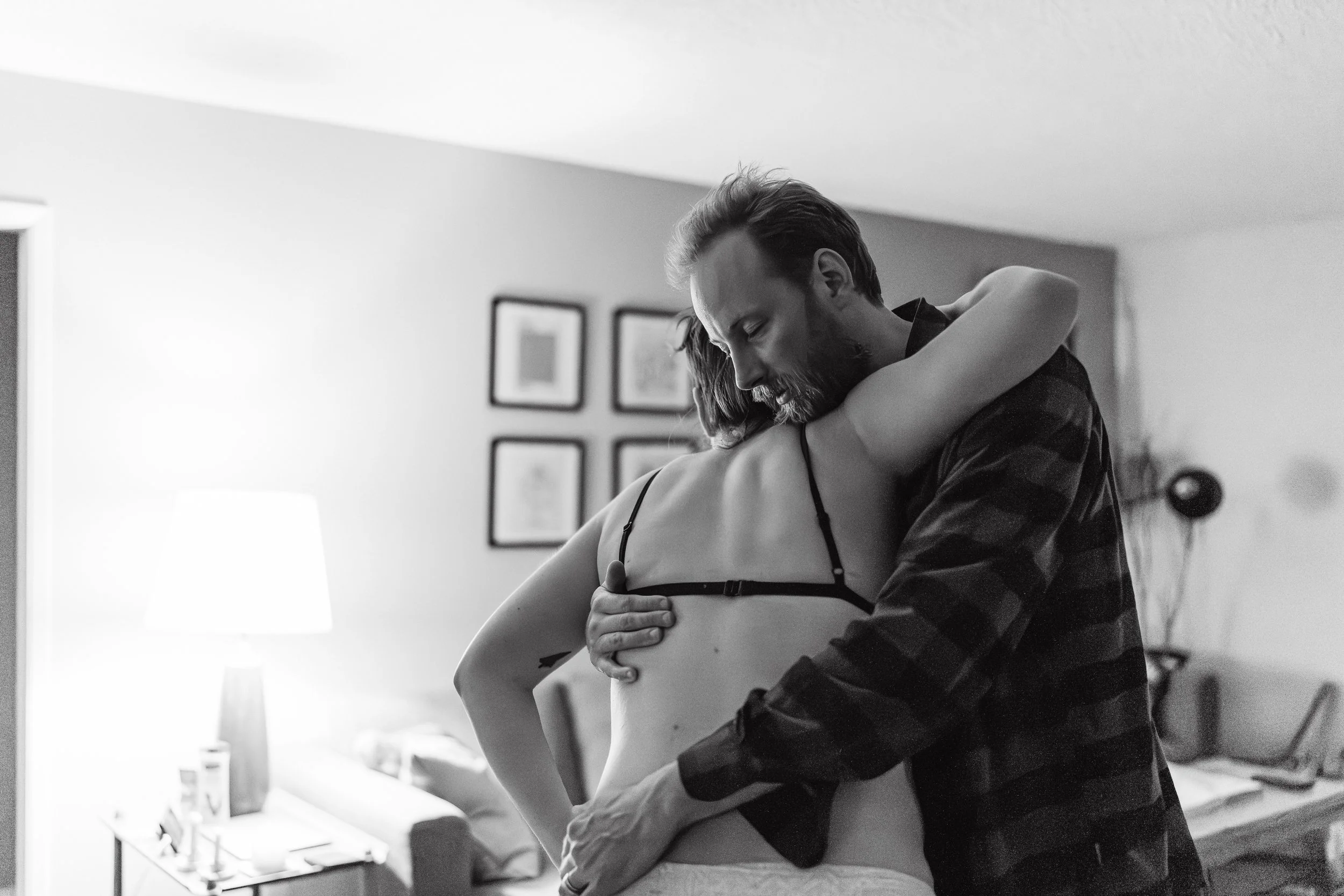 Couple embracing at a home birth as non-birthing parent supports his partner through a contraction. Captured by Laine Ferguson Birth Photographer.