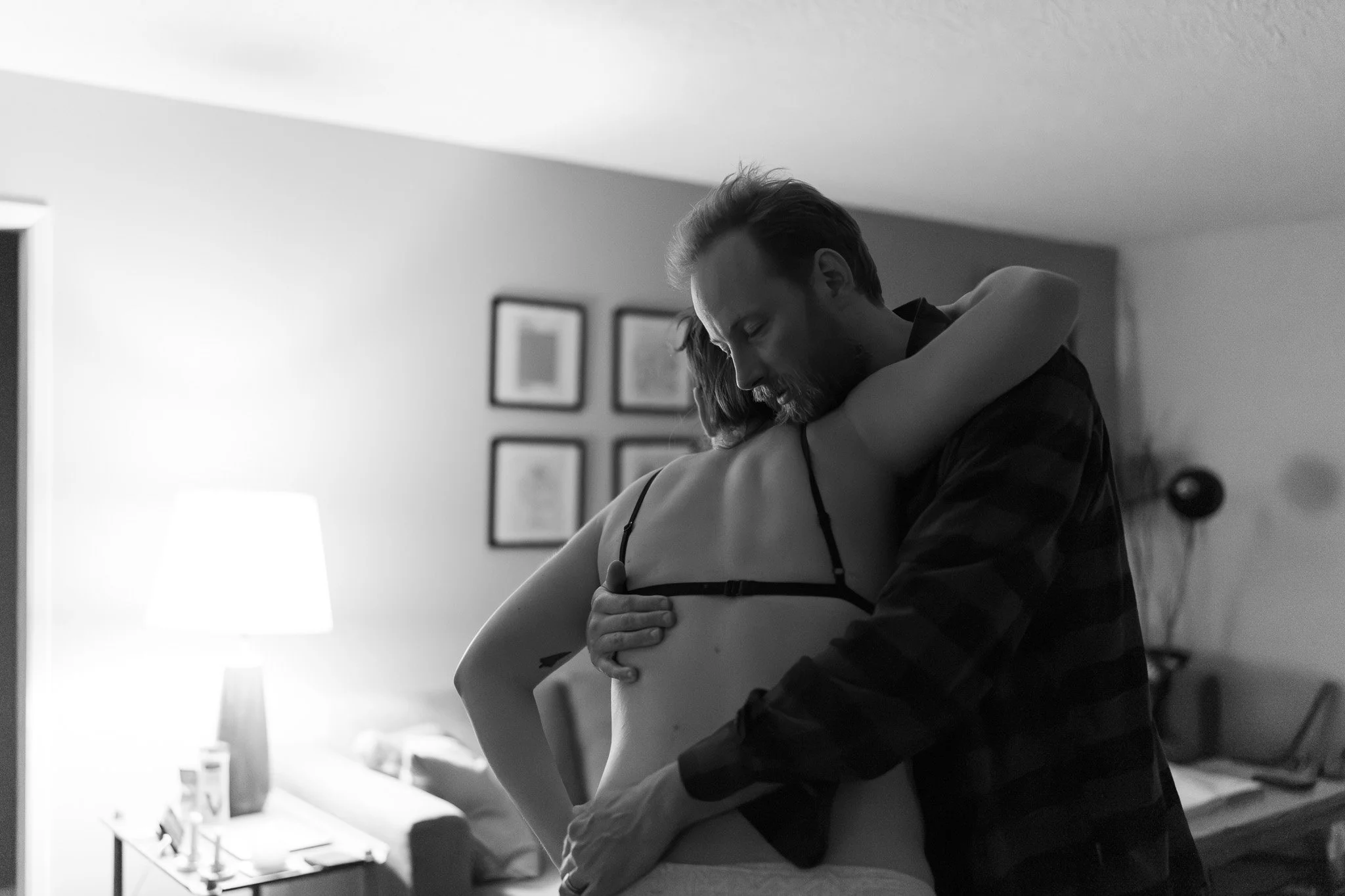 Partner supporting birthing person during active labour at a home birth, captured discreetly by Nelson BC Birth Doula and Photographer Laine Ferguson