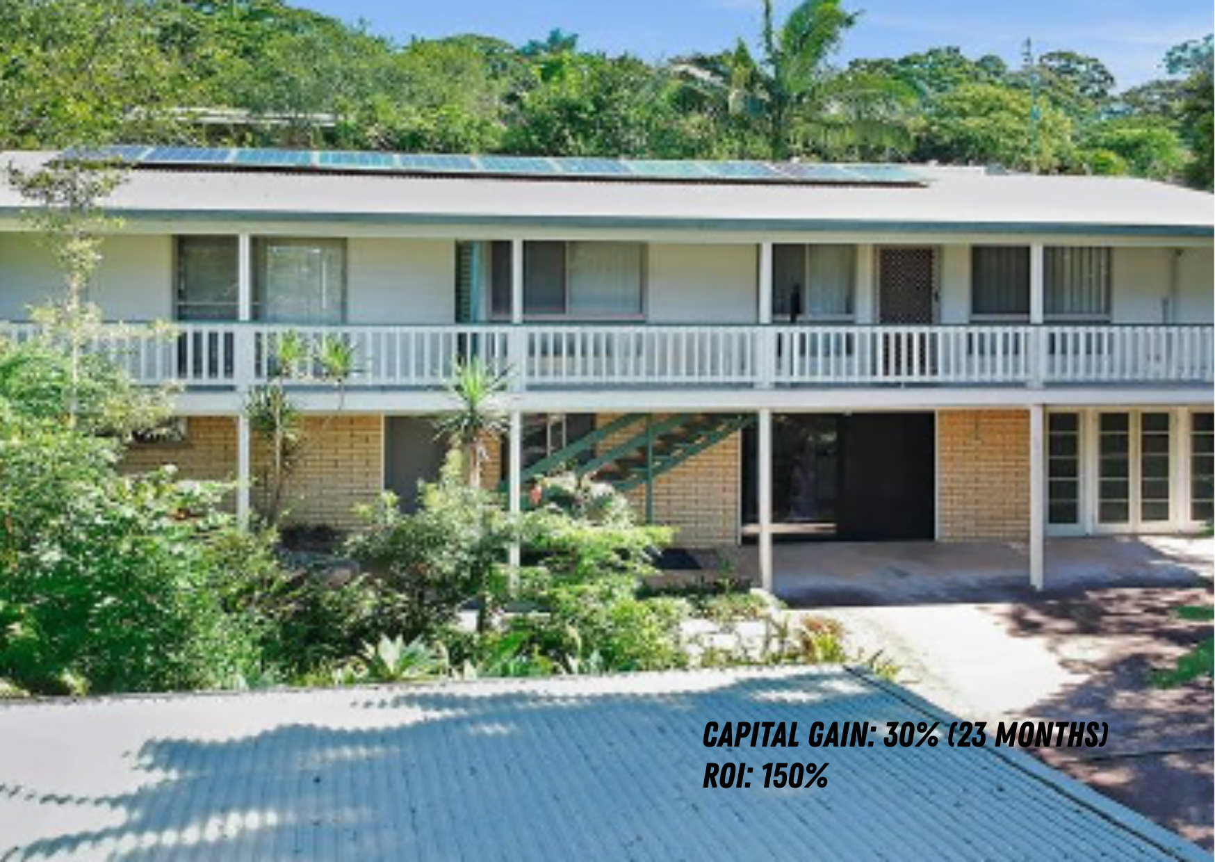 Two-story house with a white balcony railing, surrounded by green trees and plants, with solar panels on the roof. Text overlay reads: Capital gain 30% (23 months), ROI 150%.