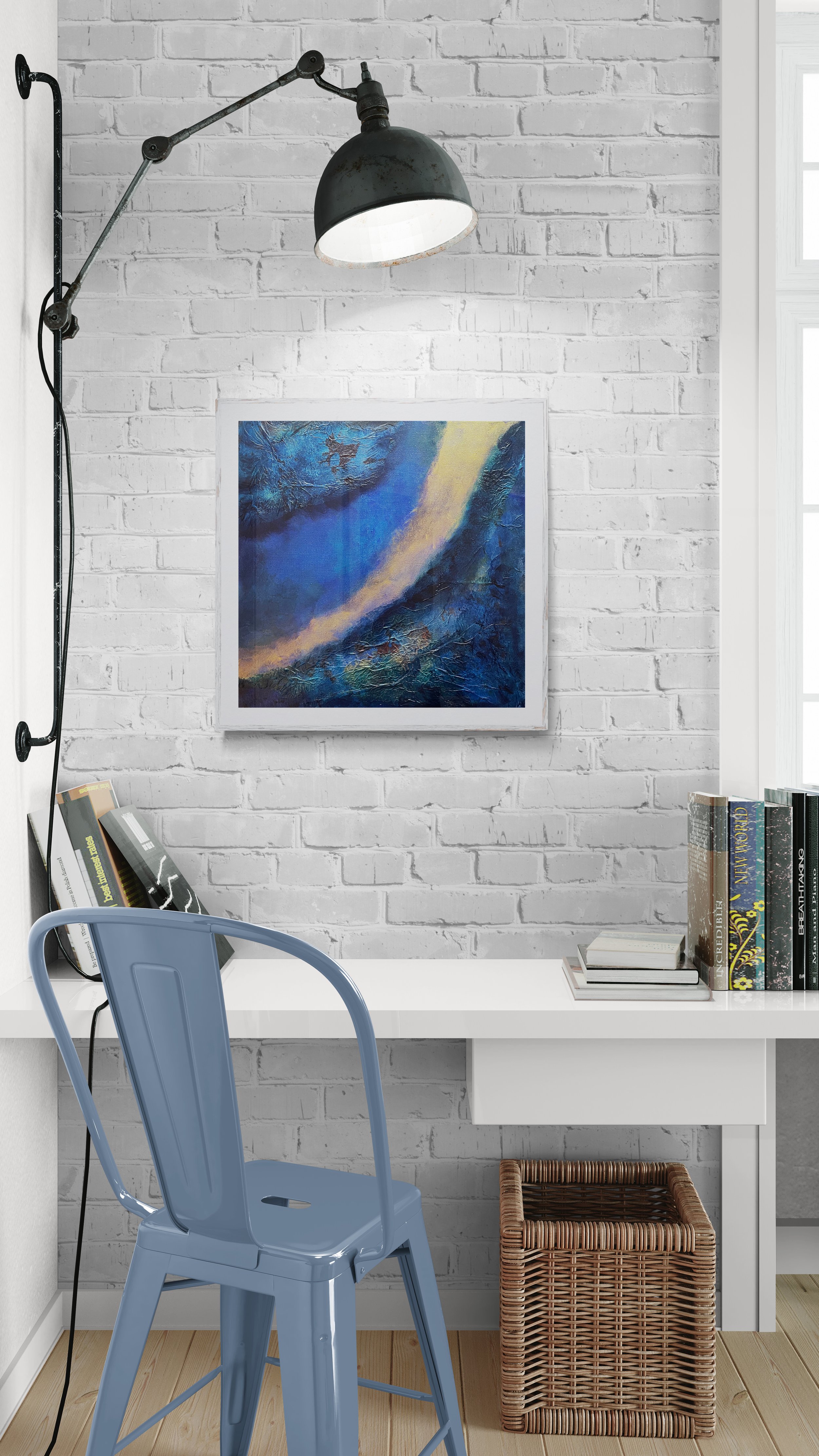 Abstract blue mixed media collage artwork by Virginie Hotte displayed in a modern workspace interior on a white brick wall.