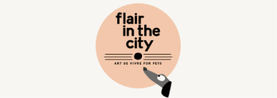 A circular logo with a peach background that reads "flair in the city" and "art de vivre for pets" underneath, with a hand drawing a black line beneath the text.