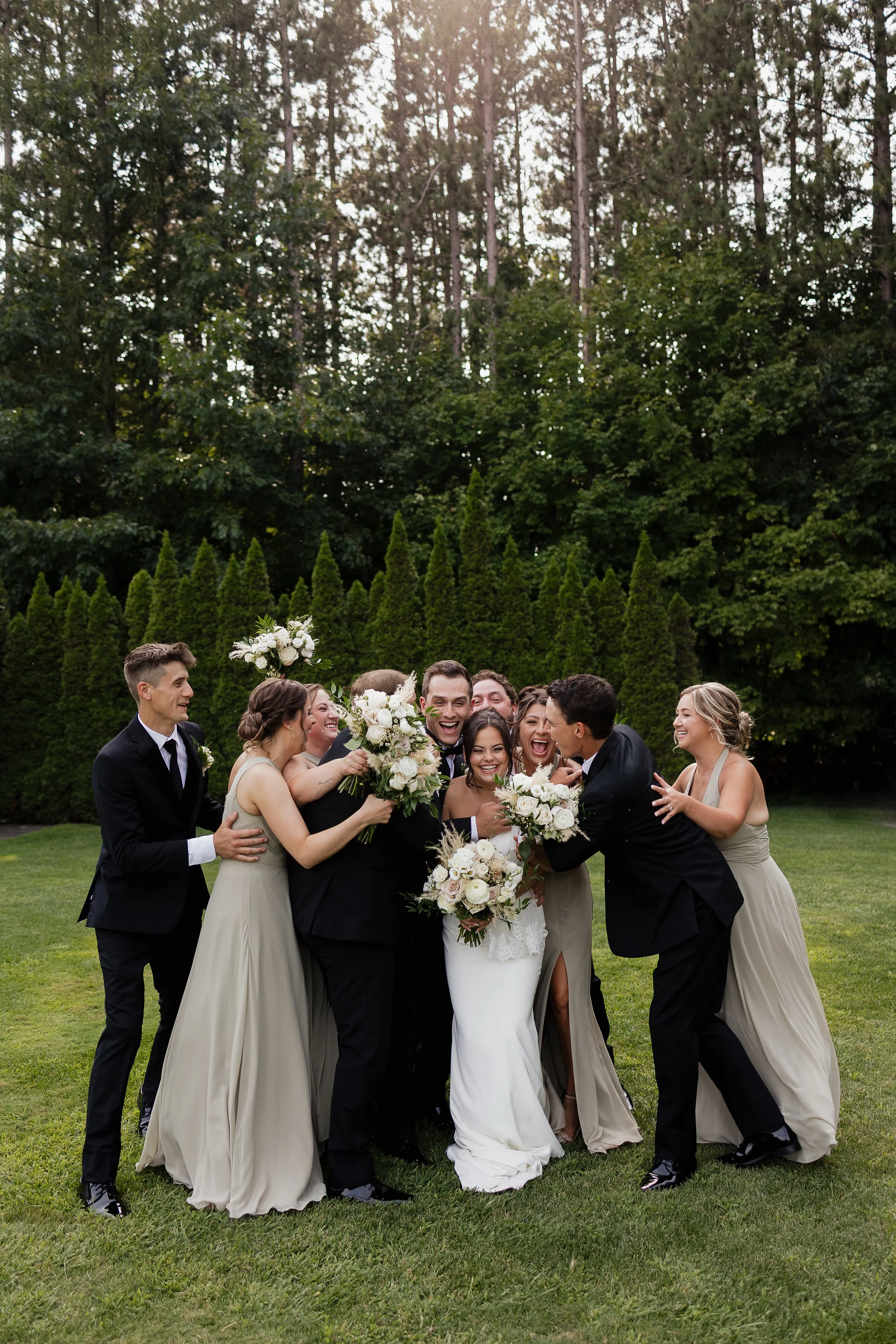 Wedding party laughing and hugging the couple, Kitchener Ontario wedding photography by James and Alyson Photography
