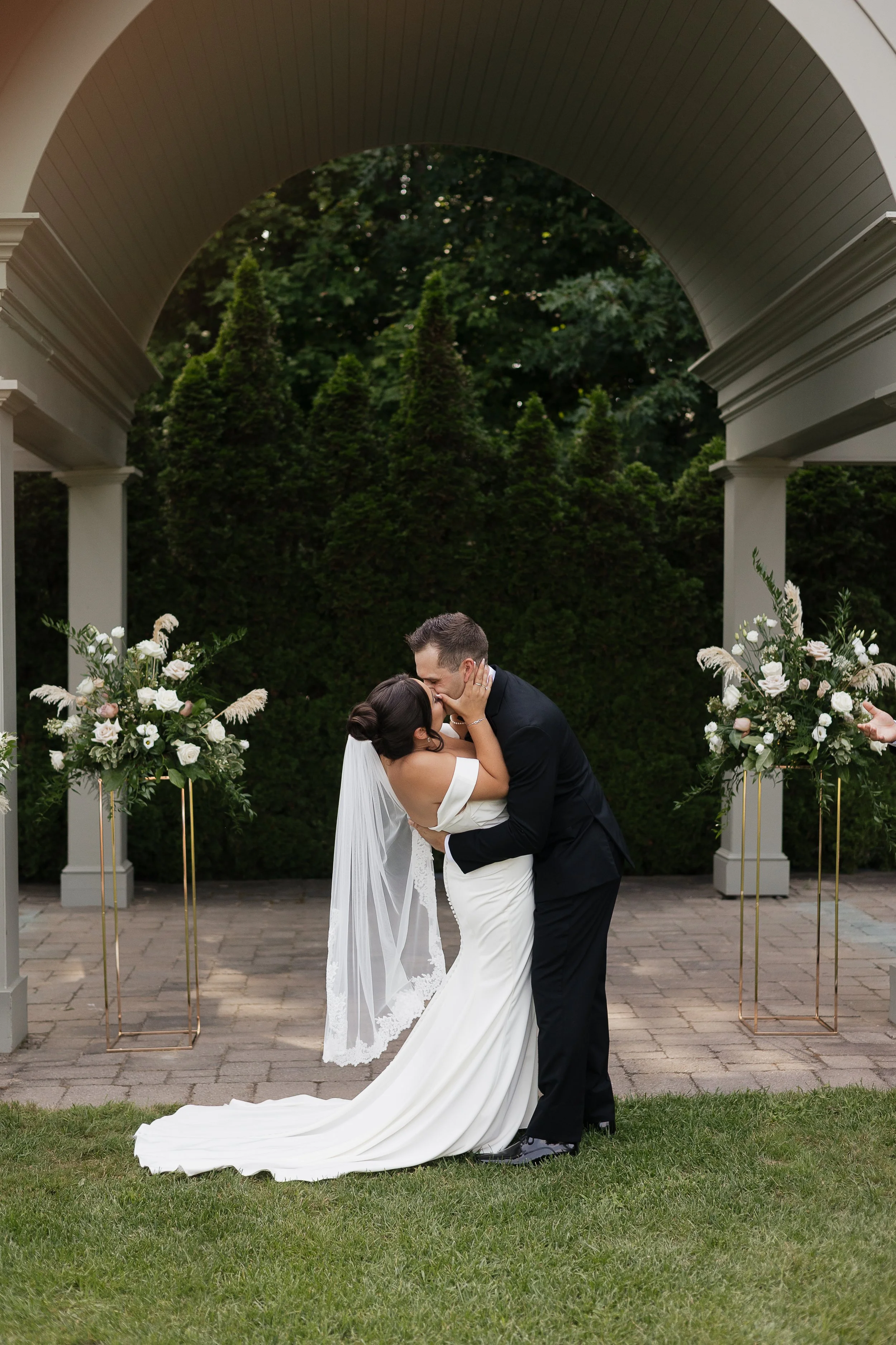 bride and groom first kiss, Ontario wedding photography by James and Alyson Photography
