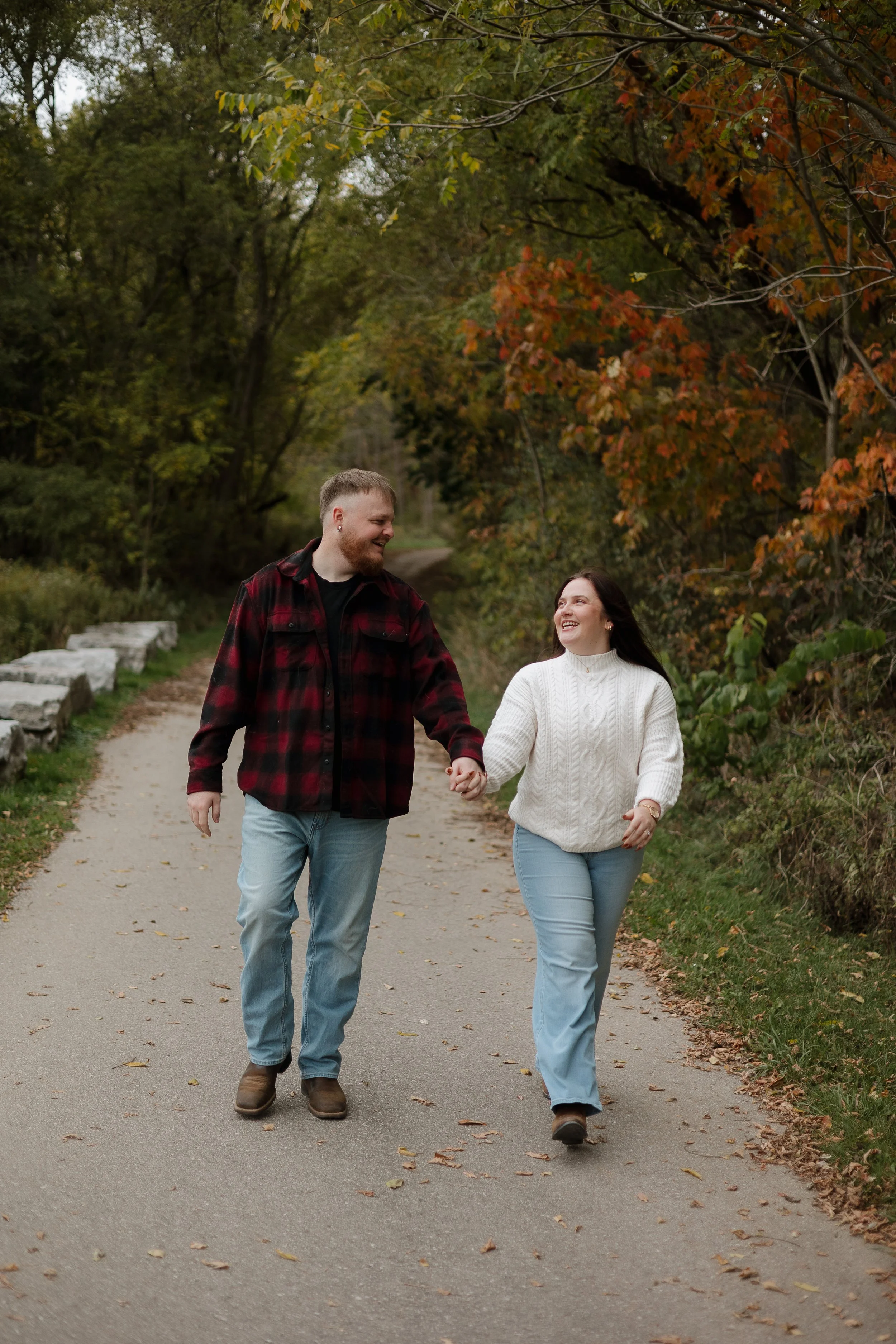Engaged couple walking hand in hand during a cozy fall engagement shoot at Penman’s Pass in Paris Ontario