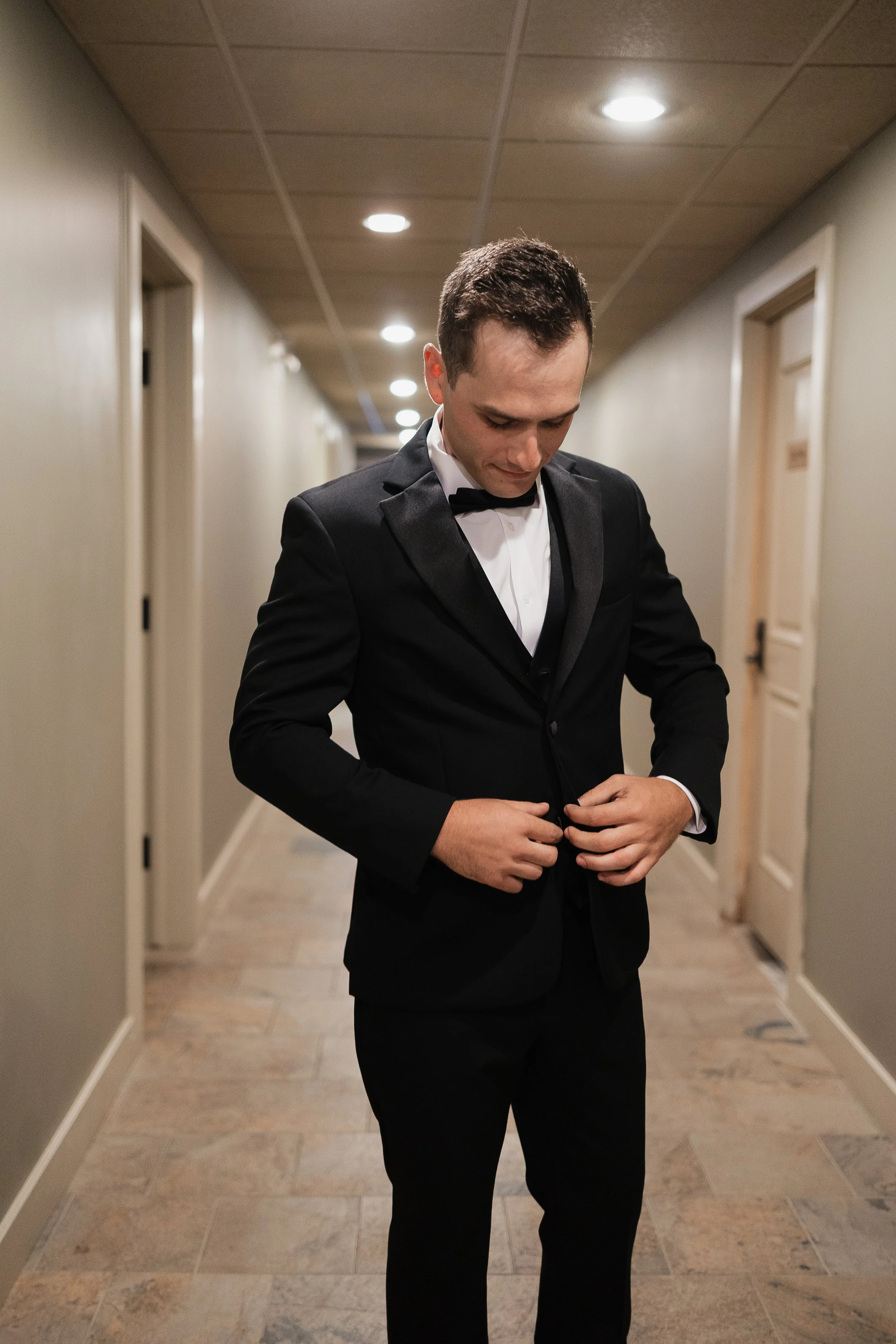groom adjusting his suit before the ceremony, Ontario wedding photography by James and Alyson Photography
