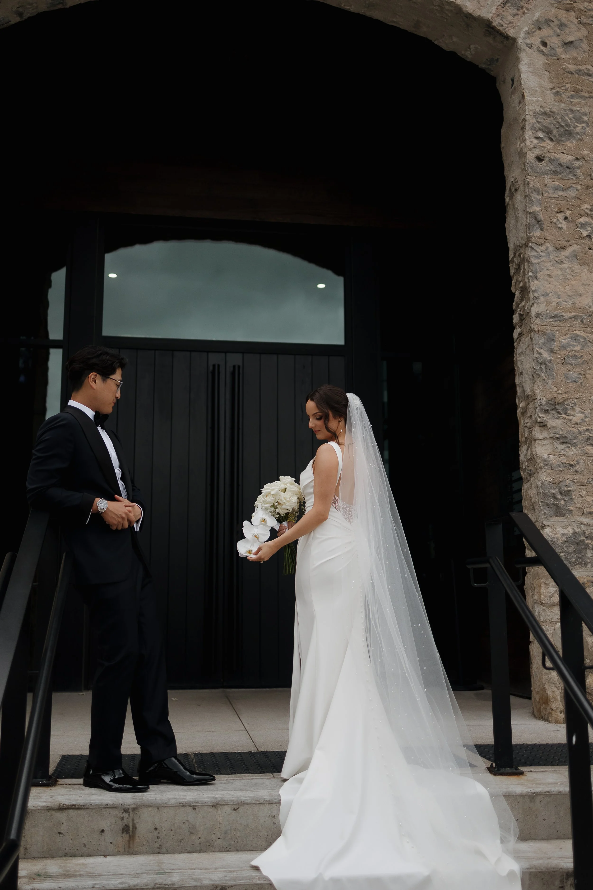 Bride and groom on stairs admiring each other, Tapestry Hall Cambridge wedding, Ontario wedding photography by James and Alyson Photography