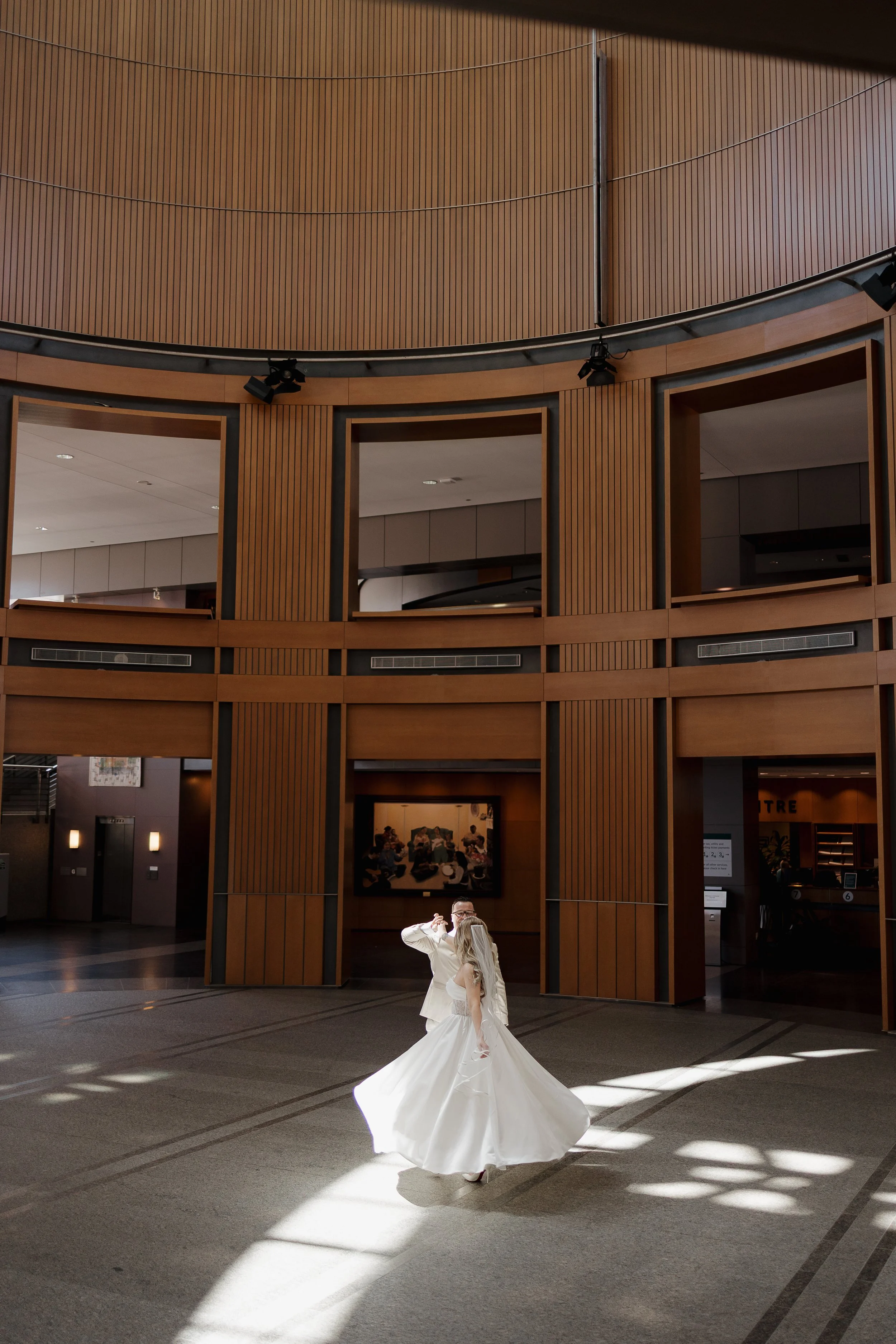 Bride twirling in wedding dress during elopement at Downtown Kitchener City Hall, photographed by James & Alyson Photography