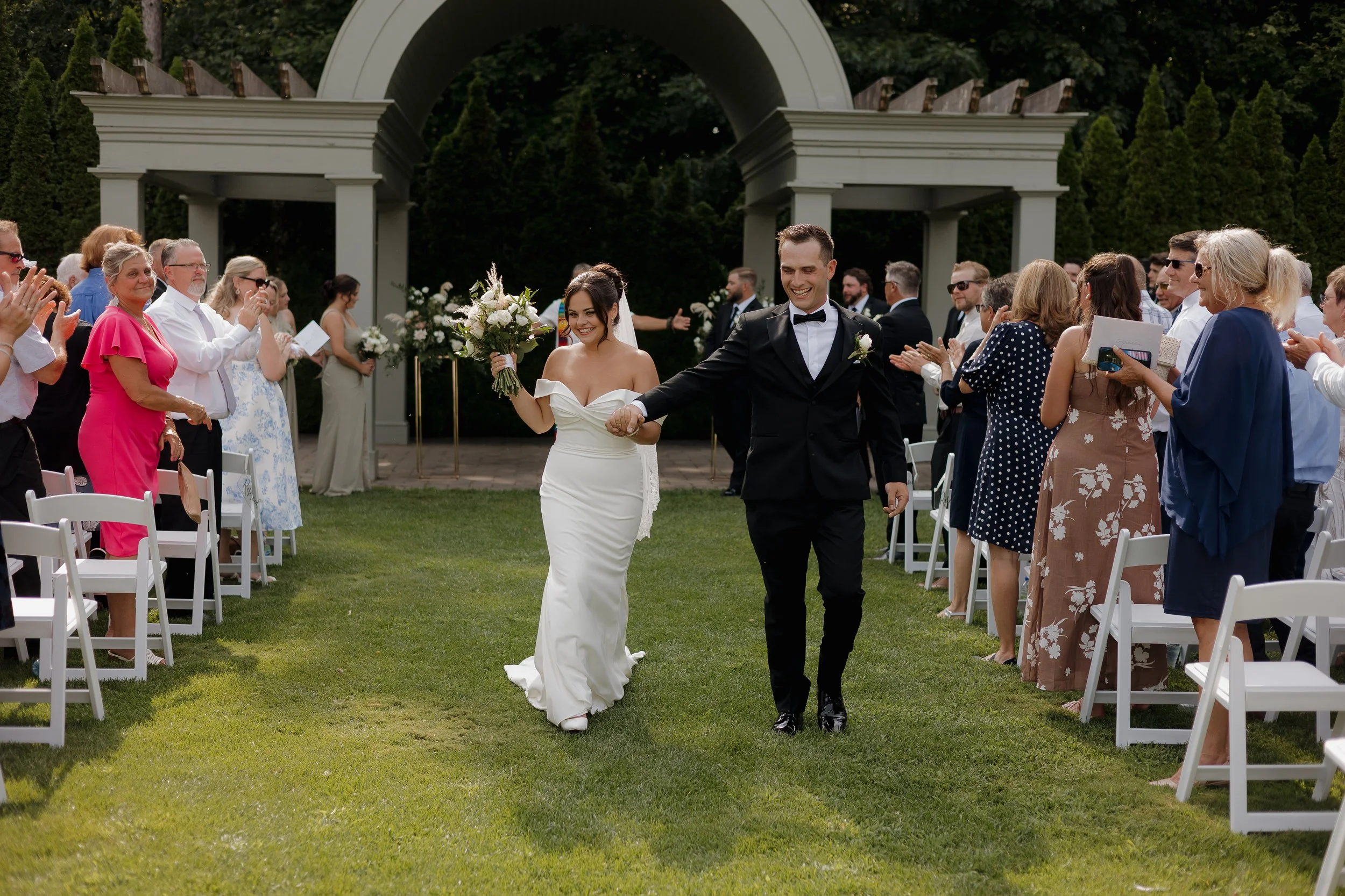 bride and groom excitedly walking down the aisle after ceremony, Ontario wedding photography by James and Alyson Photography