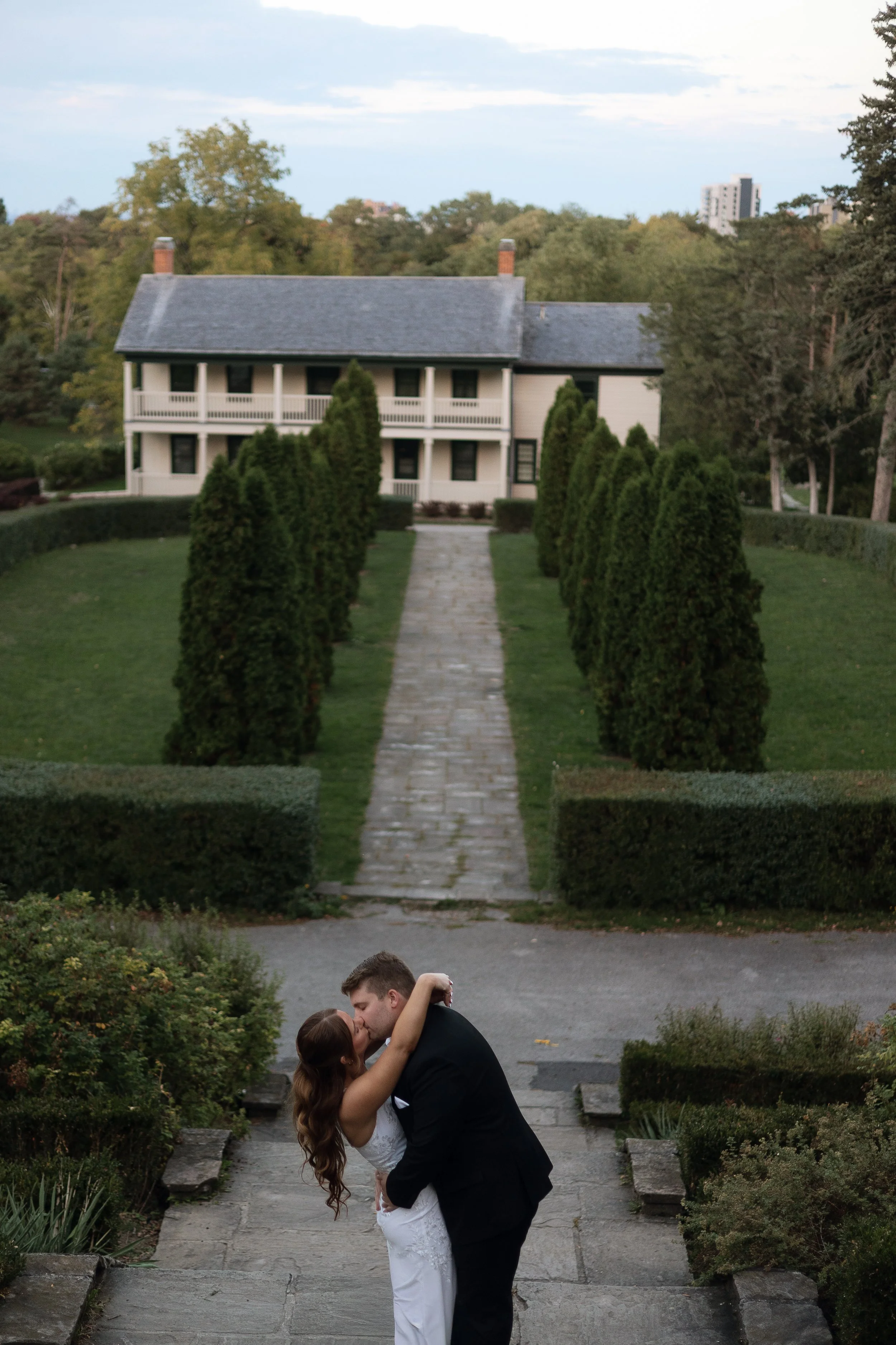 Couple embracing during an engagement session at Battlefield House and Museum, Hamilton Ontario
