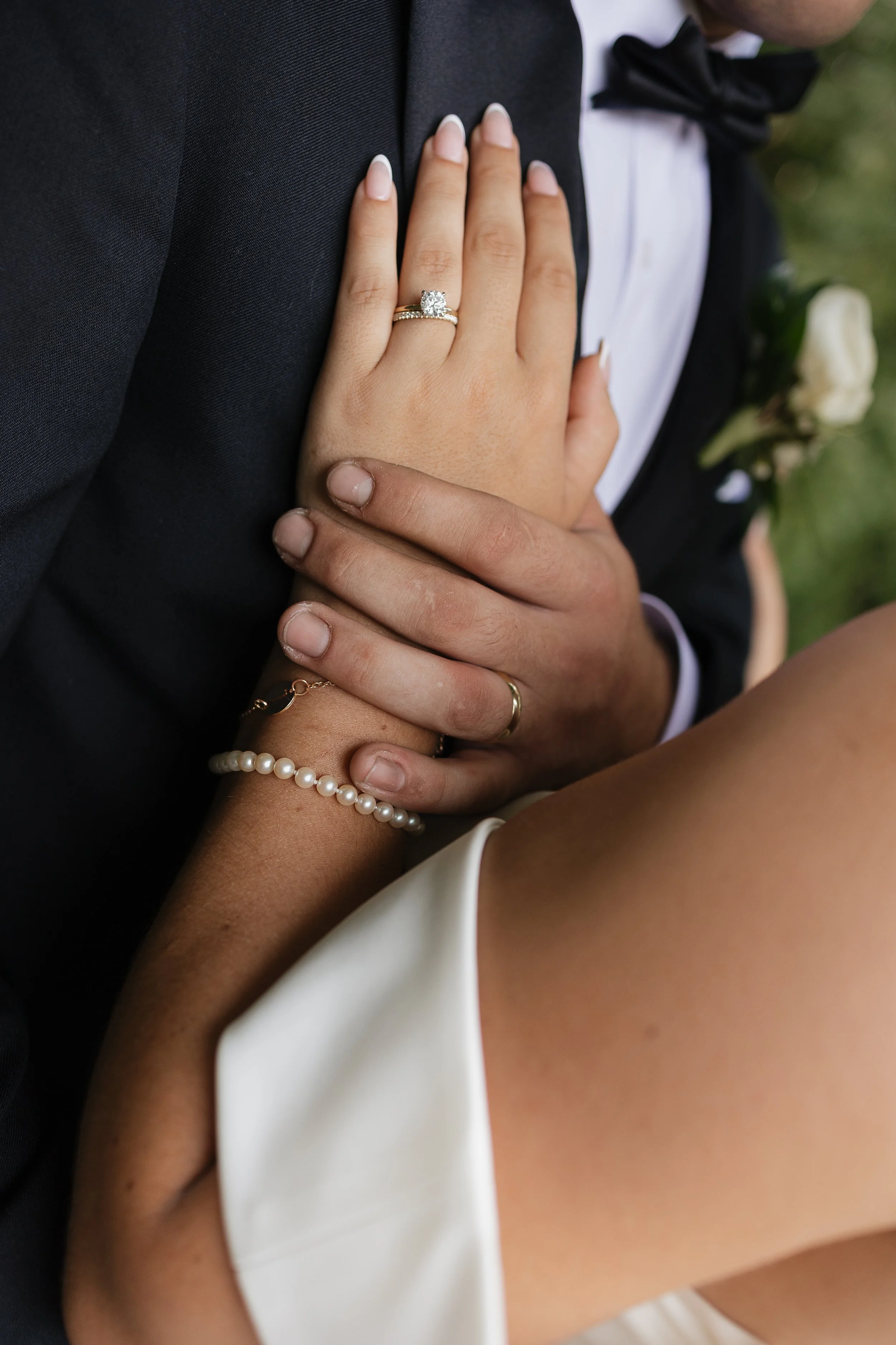 Groom holding bride’s wrist showing wedding rings, wedding detail photography, Ontario wedding photographer