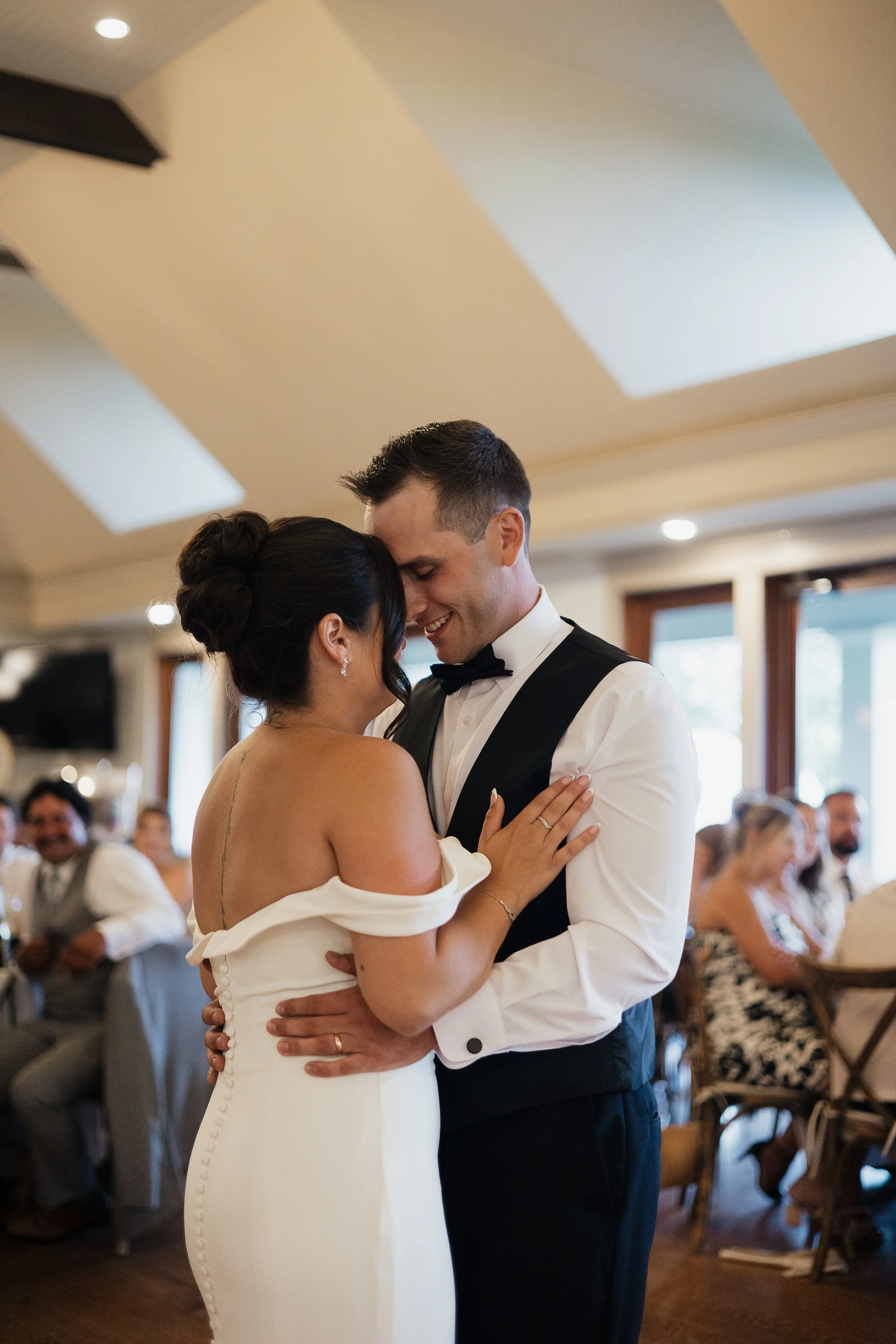 bride and groom embracing during their first dance, Ontario wedding photography by James and Alyson Photography