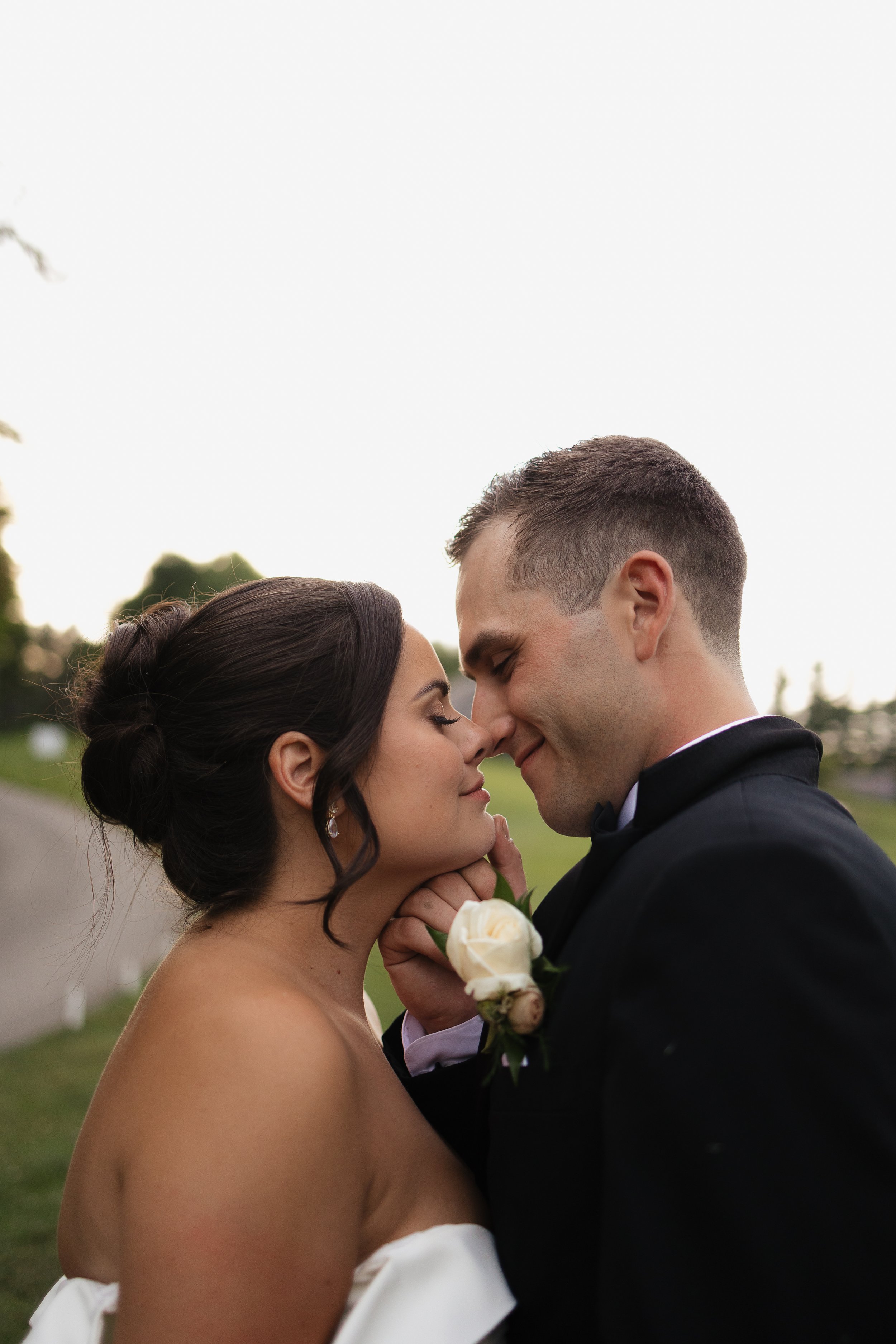 groom bringing the bride in for a kiss, Ontario wedding photography by James and Alyson Photography