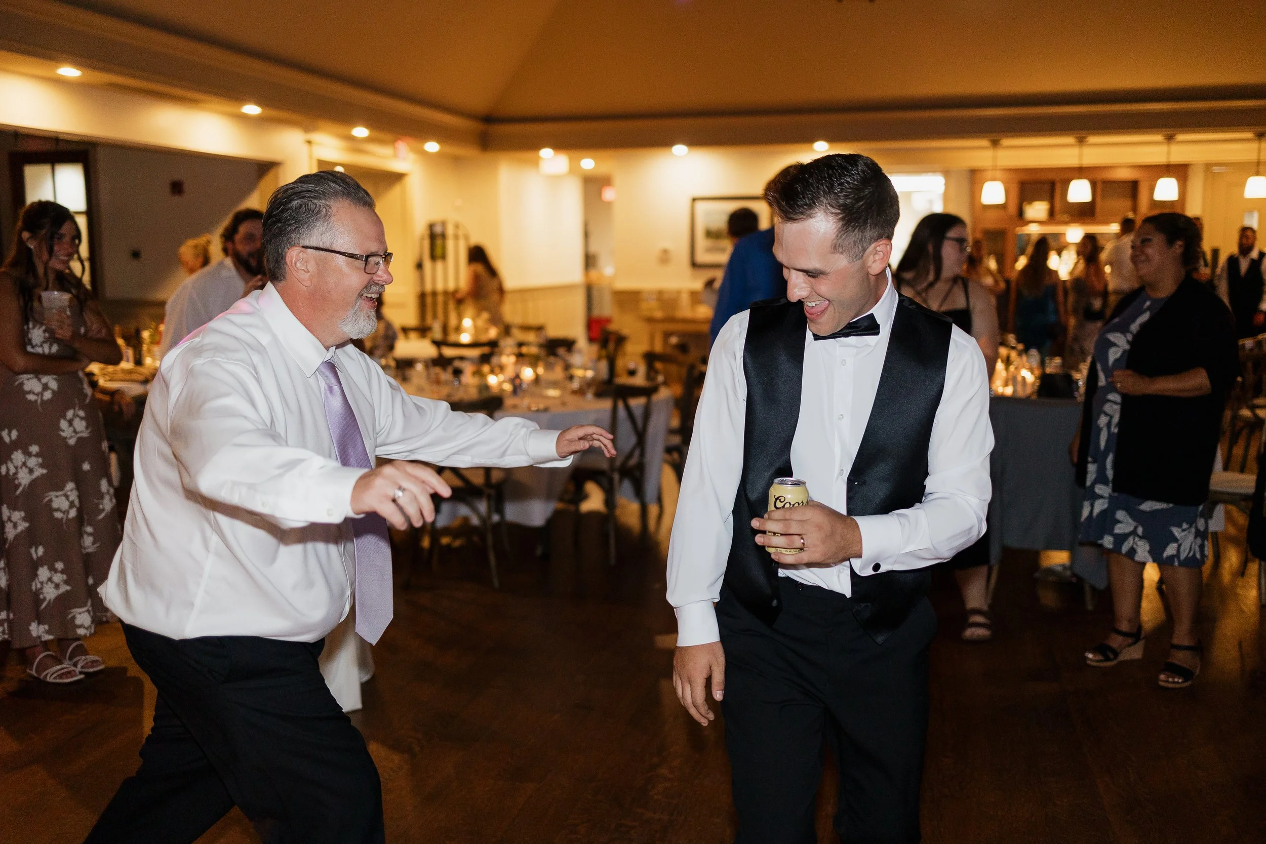 groom dancing with a guest, Ontario wedding photography by James and Alyson Photography